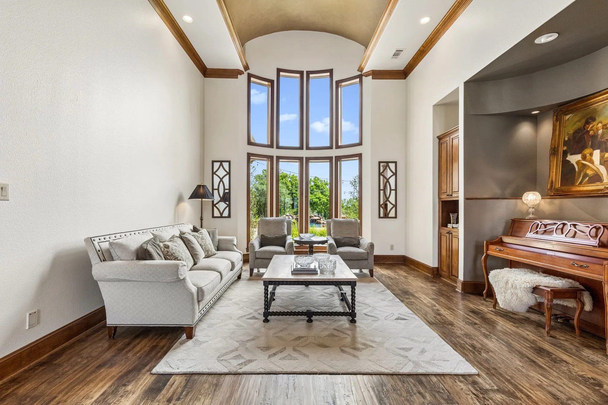 Living area featuring high ceilings, large windows providing natural light, and hardwood flooring