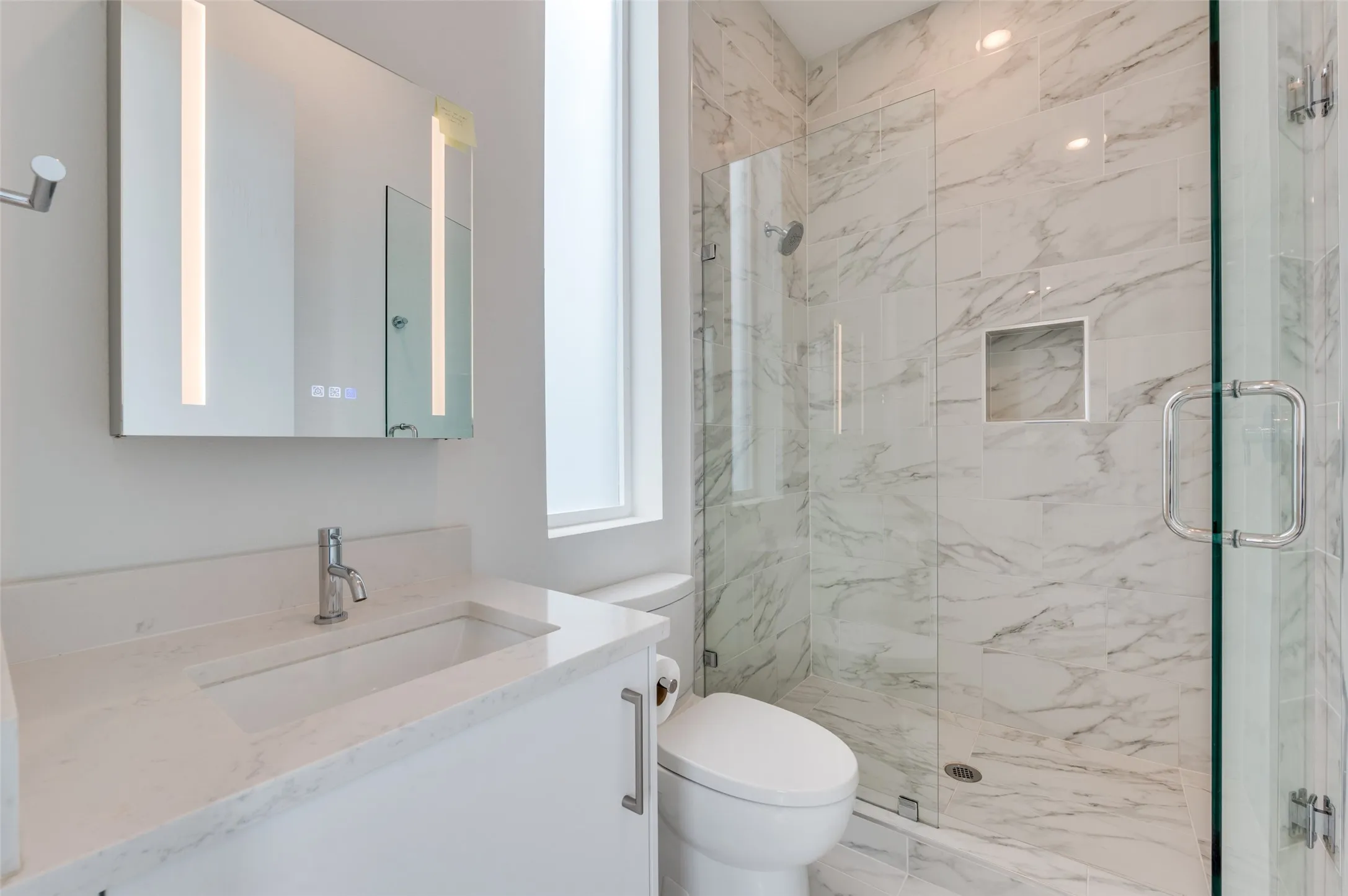 The bathroom features a modern vanity with an integrated sink and a sleek faucet