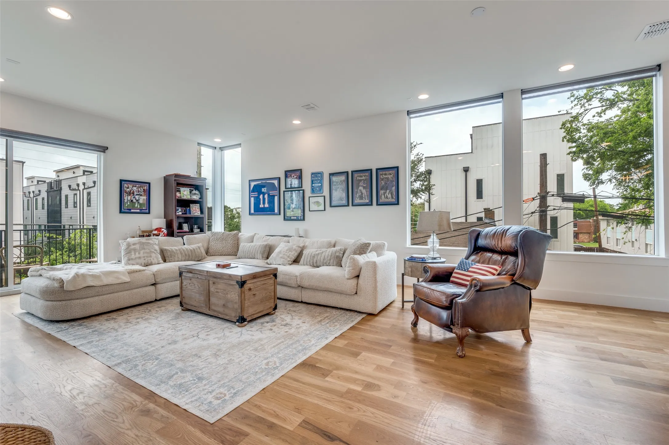 Living area featuring hardwood floors, recessed lighting, and expansive windows providing natural light
