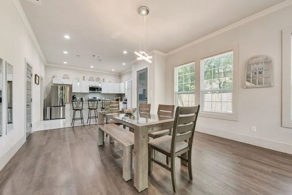 Open concept living space featuring wood flooring, recessed lighting, and crown molding