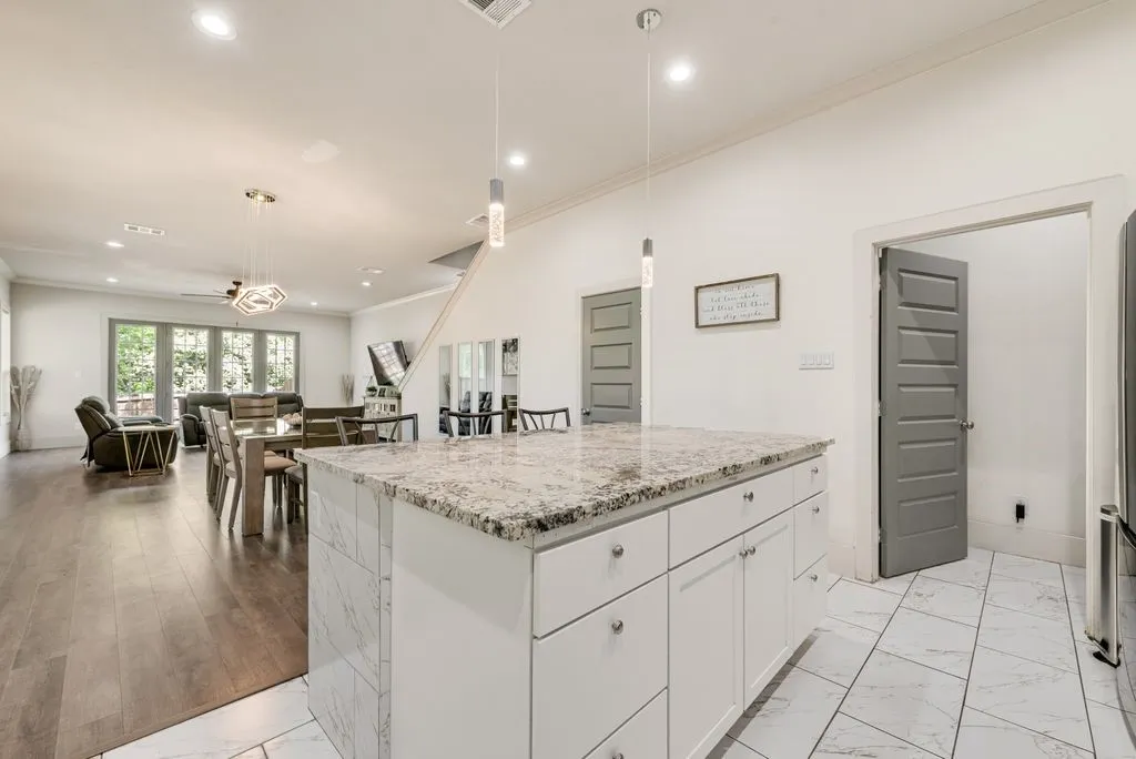 This property features an open-concept living space with dark wood flooring and large windows providing ample natural light
