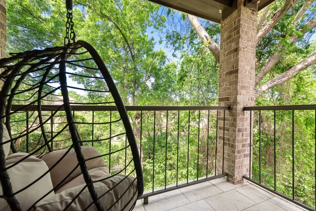Private balcony featuring a brick column, metal railings, and tiled flooring