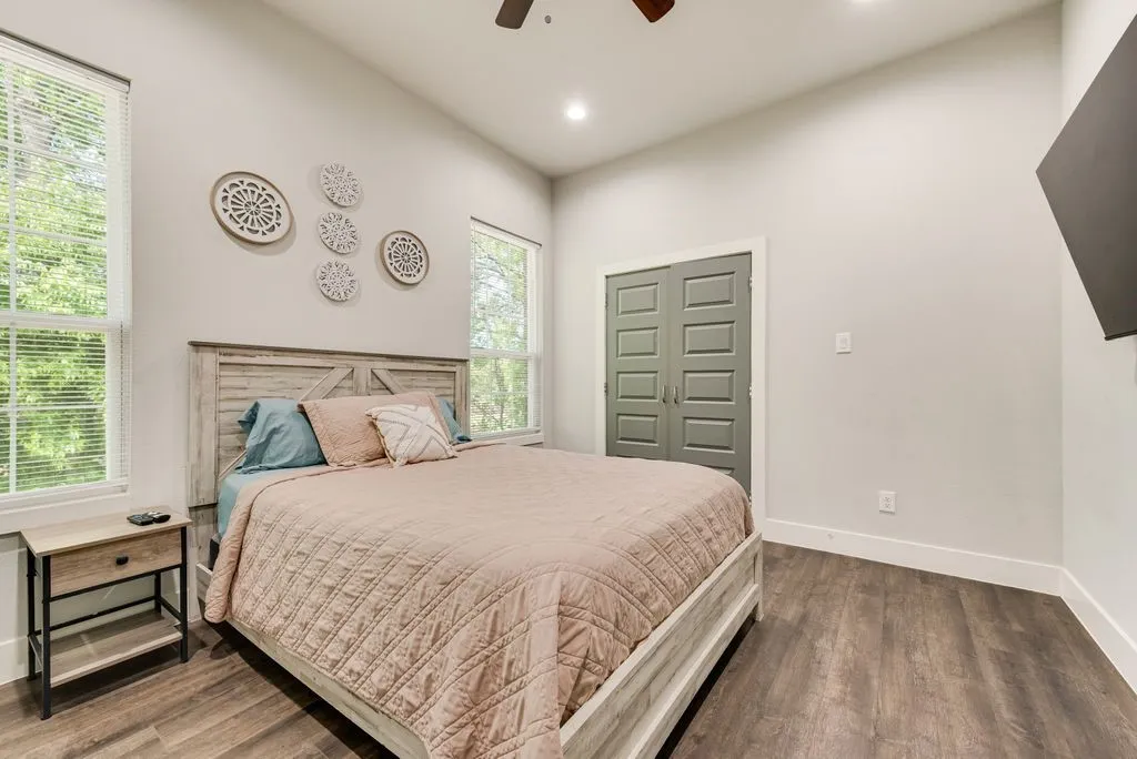 This inviting room features wood-look flooring, light gray walls, and a ceiling fan