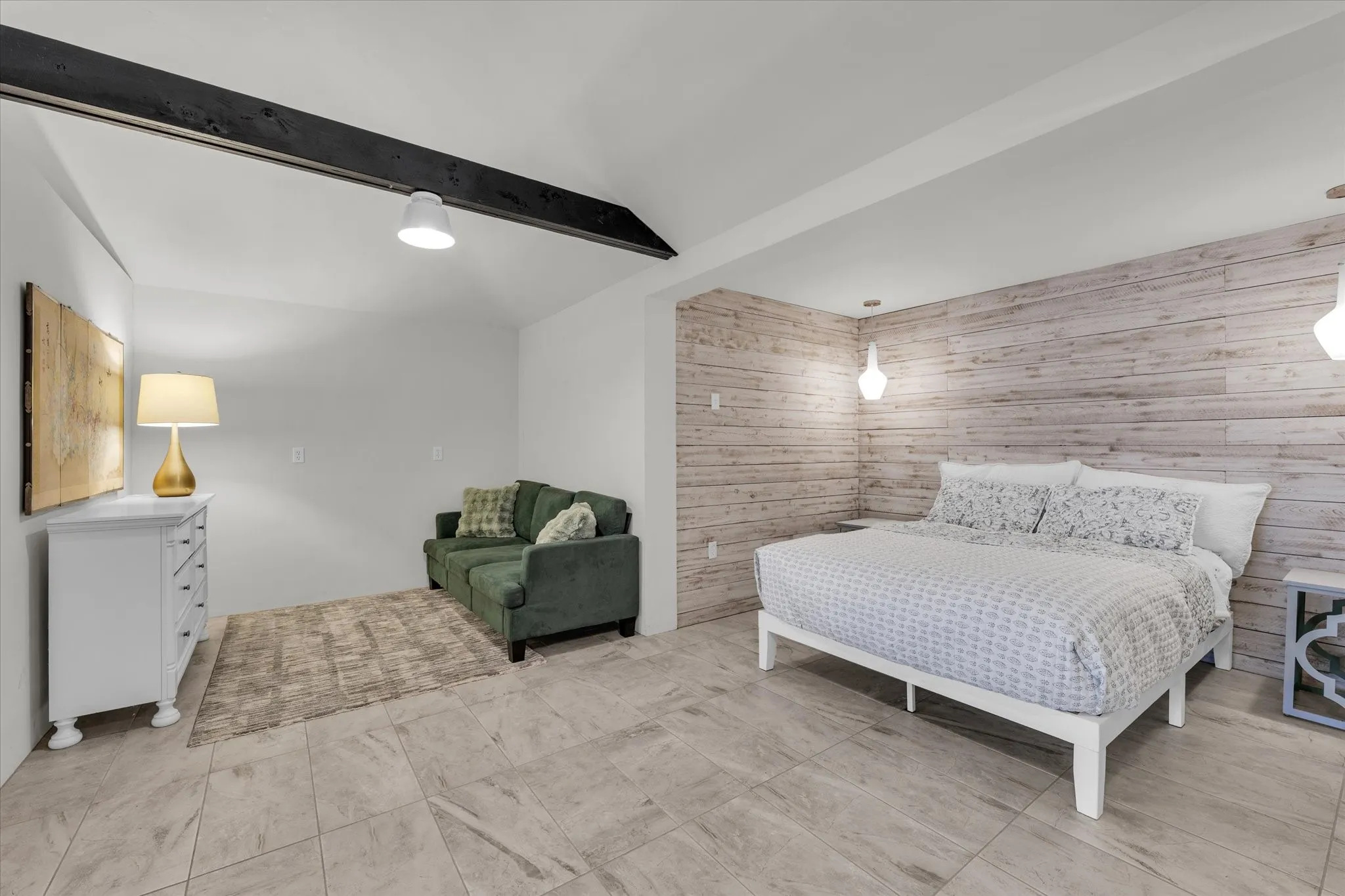 Bedroom with ceiling fan, wooden walls, an accent wall, and a walk-in closet