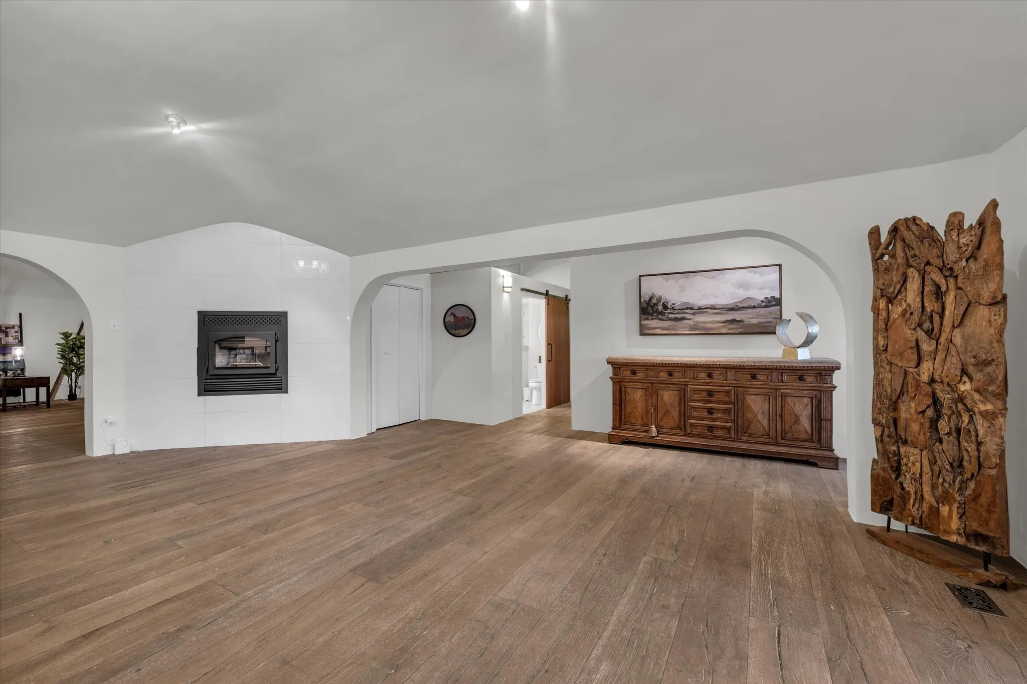 View from kitchen featuring arched walkways and wood finished floors