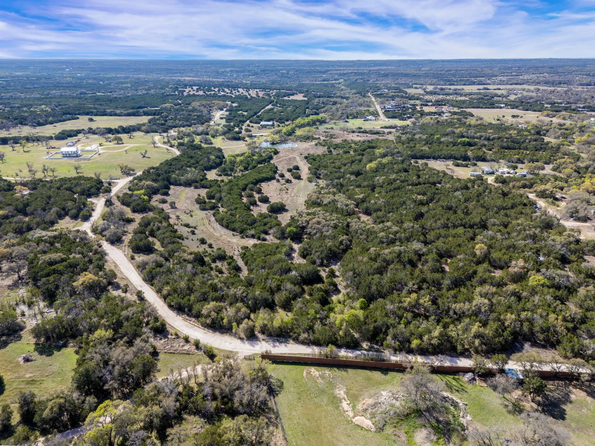 This expansive property offers a blend of wooded areas and open grassy spaces