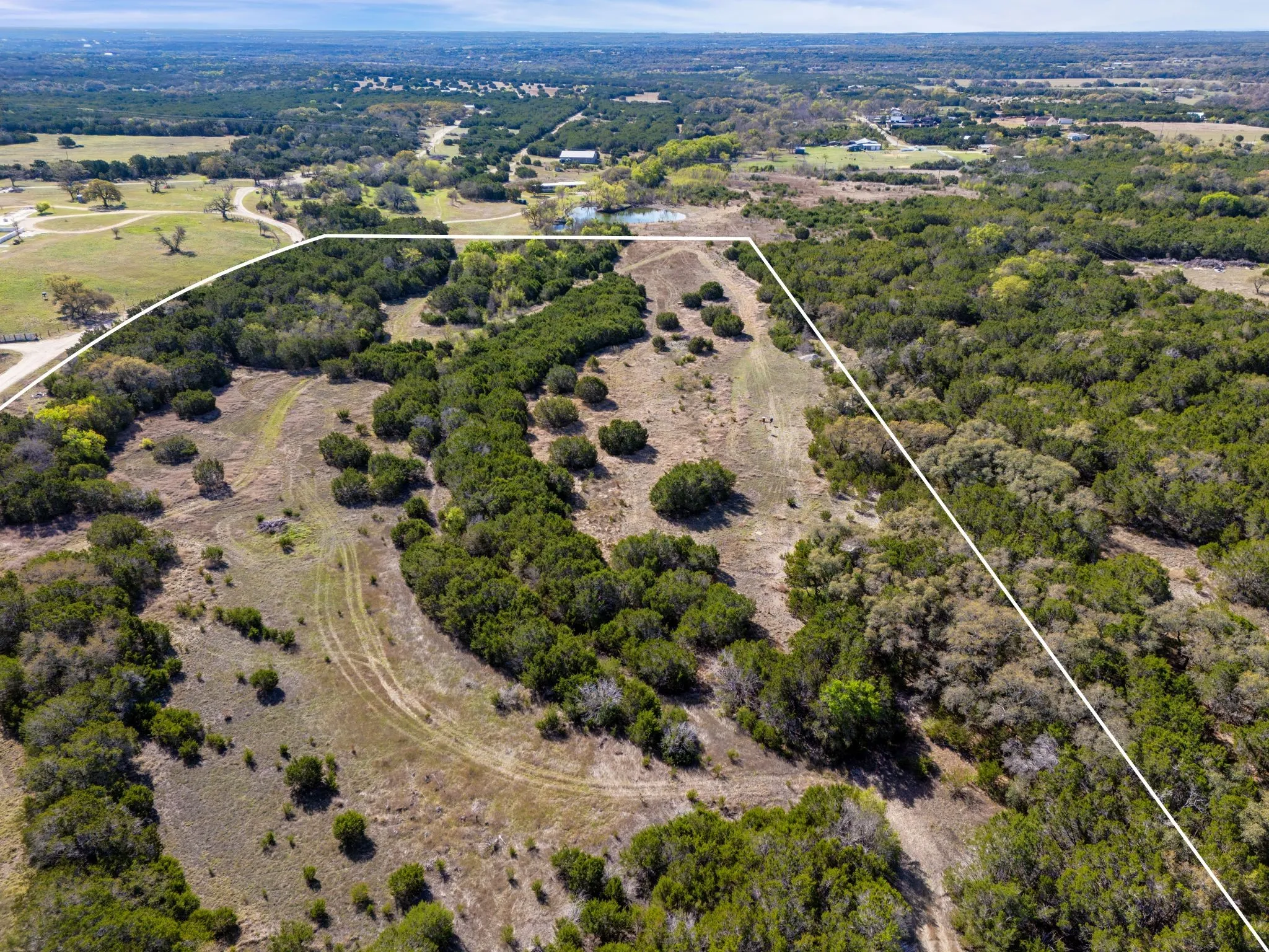 Expansive undeveloped property featuring a mix of open land and mature trees, offering a serene environment