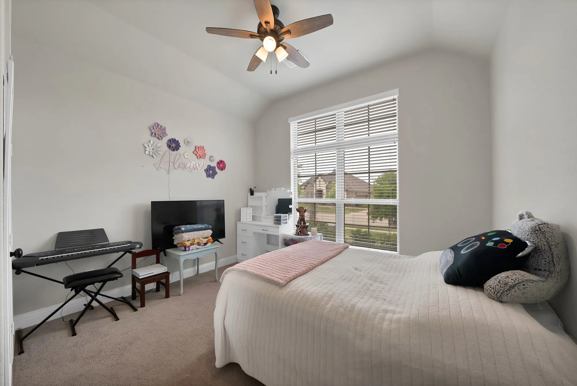 This room features an angled ceiling and a window with blinds, allowing for natural light