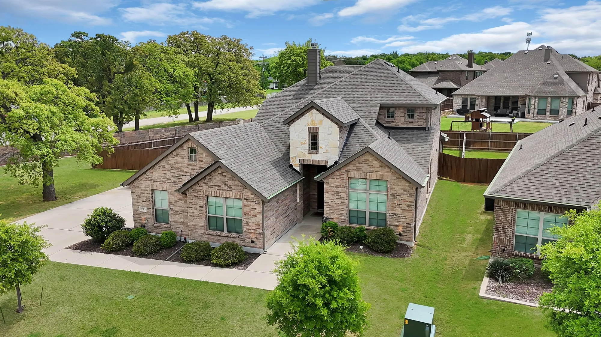 The property features a brick exterior with stone accents and a gray shingle roof