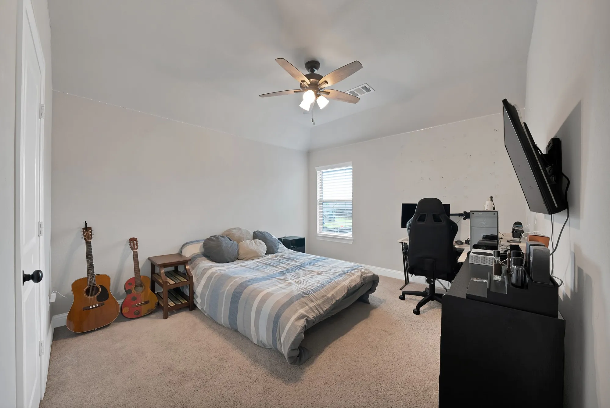 This room features carpeted flooring, a ceiling fan, and a window with blinds