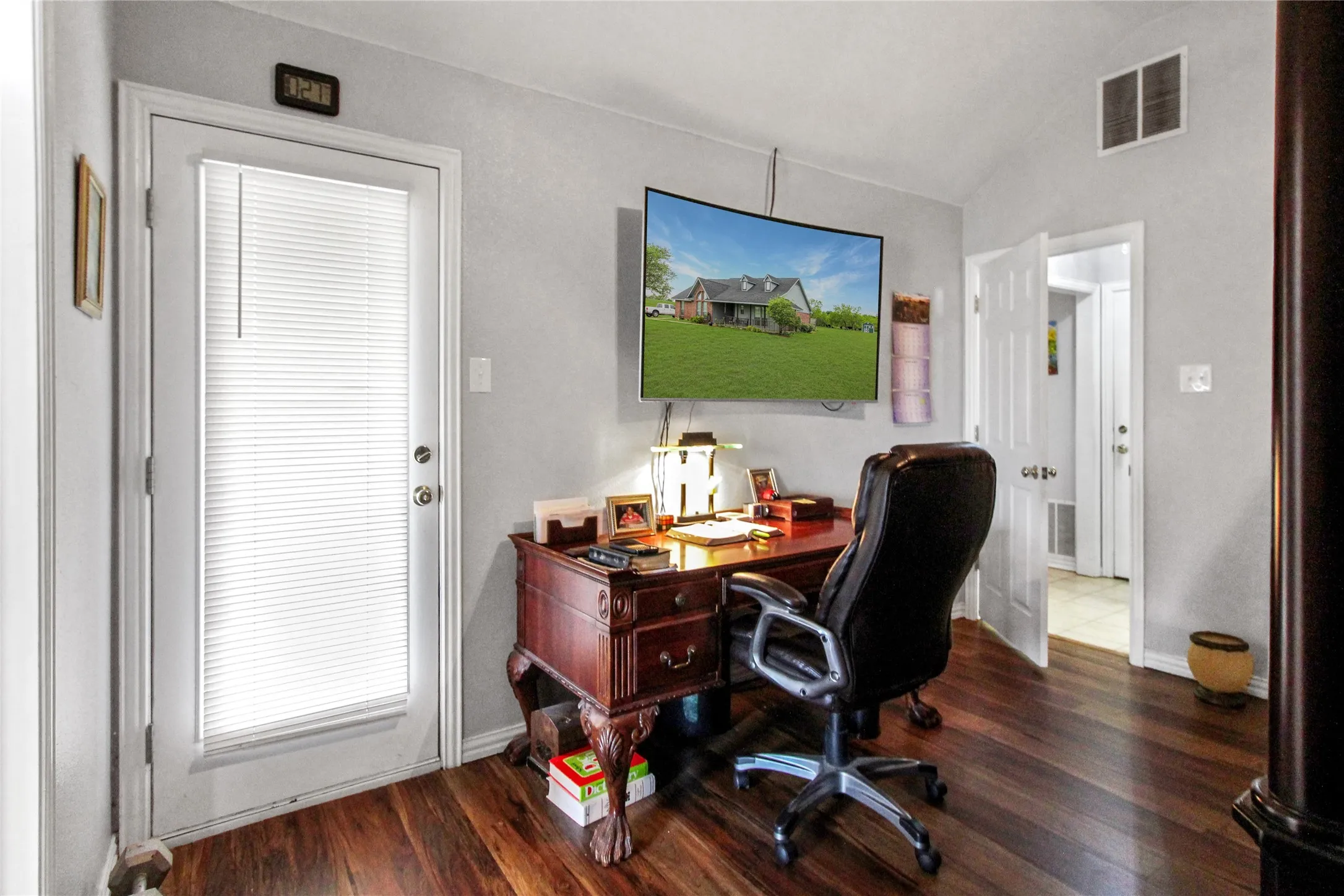 Rich wood-finish flooring complements the light gray walls