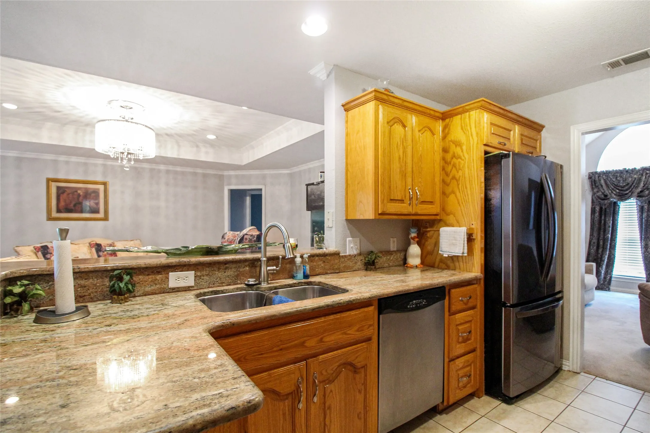 Kitchen featuring wood cabinetry, granite countertops, a double basin stainless steel sink, and stainless steel appliances