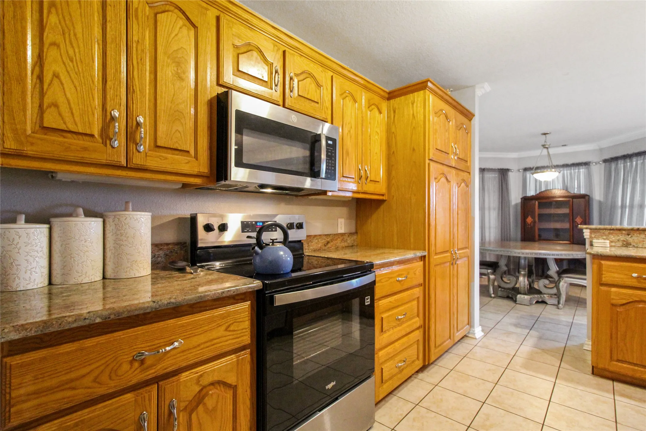 Kitchen featuring wood cabinetry, stainless steel appliances, and granite countertops