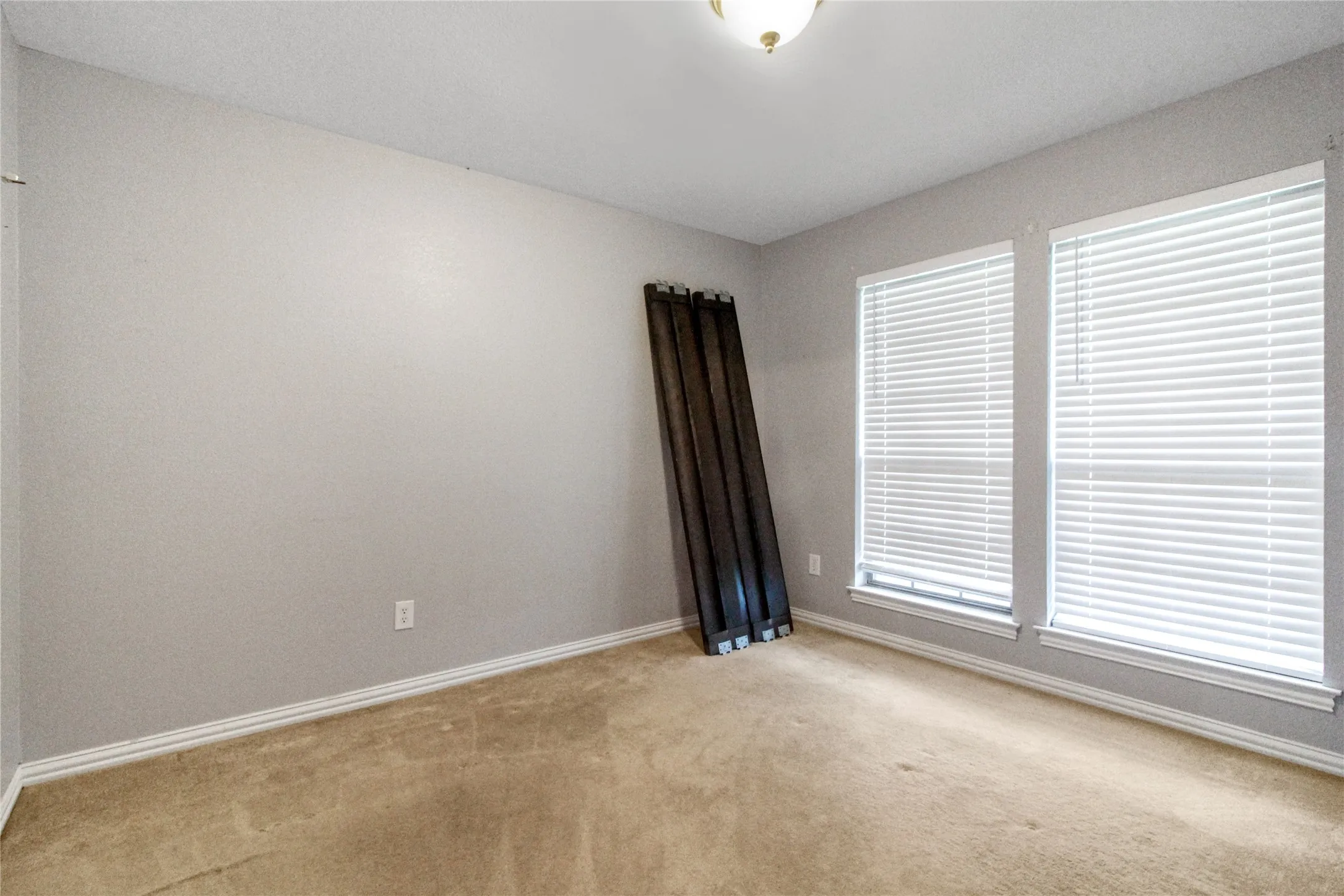 Neutral-toned room featuring a light beige carpet and white trim