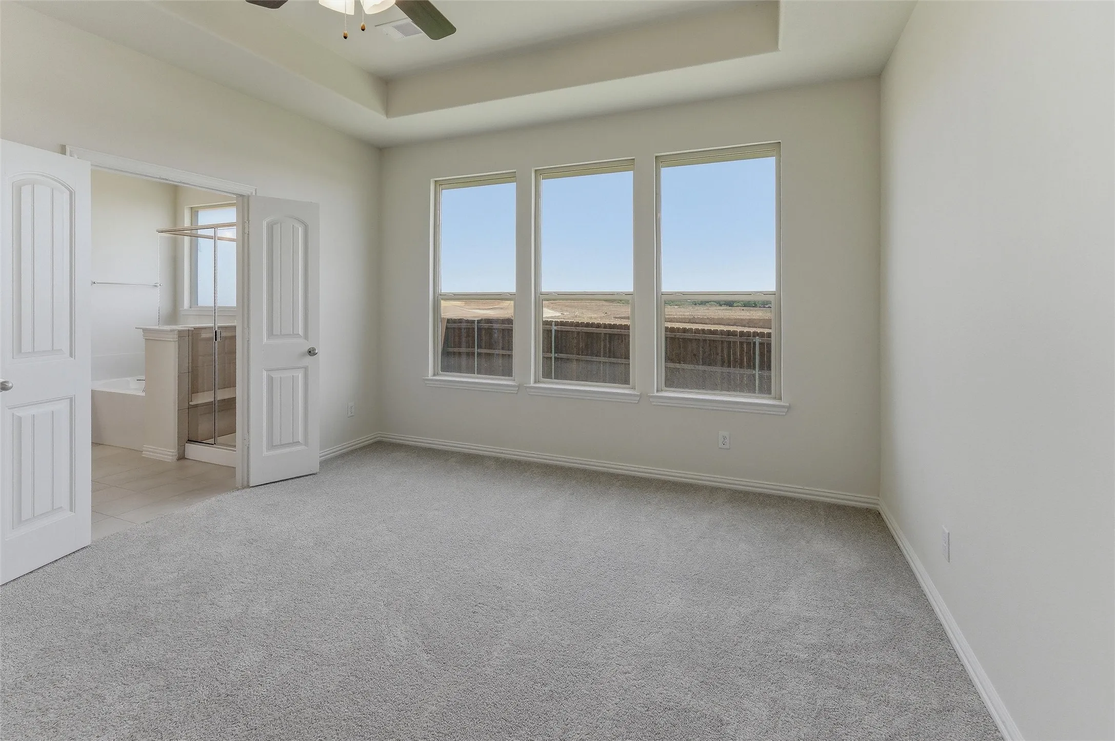 Spacious room featuring light-colored carpeting and white walls