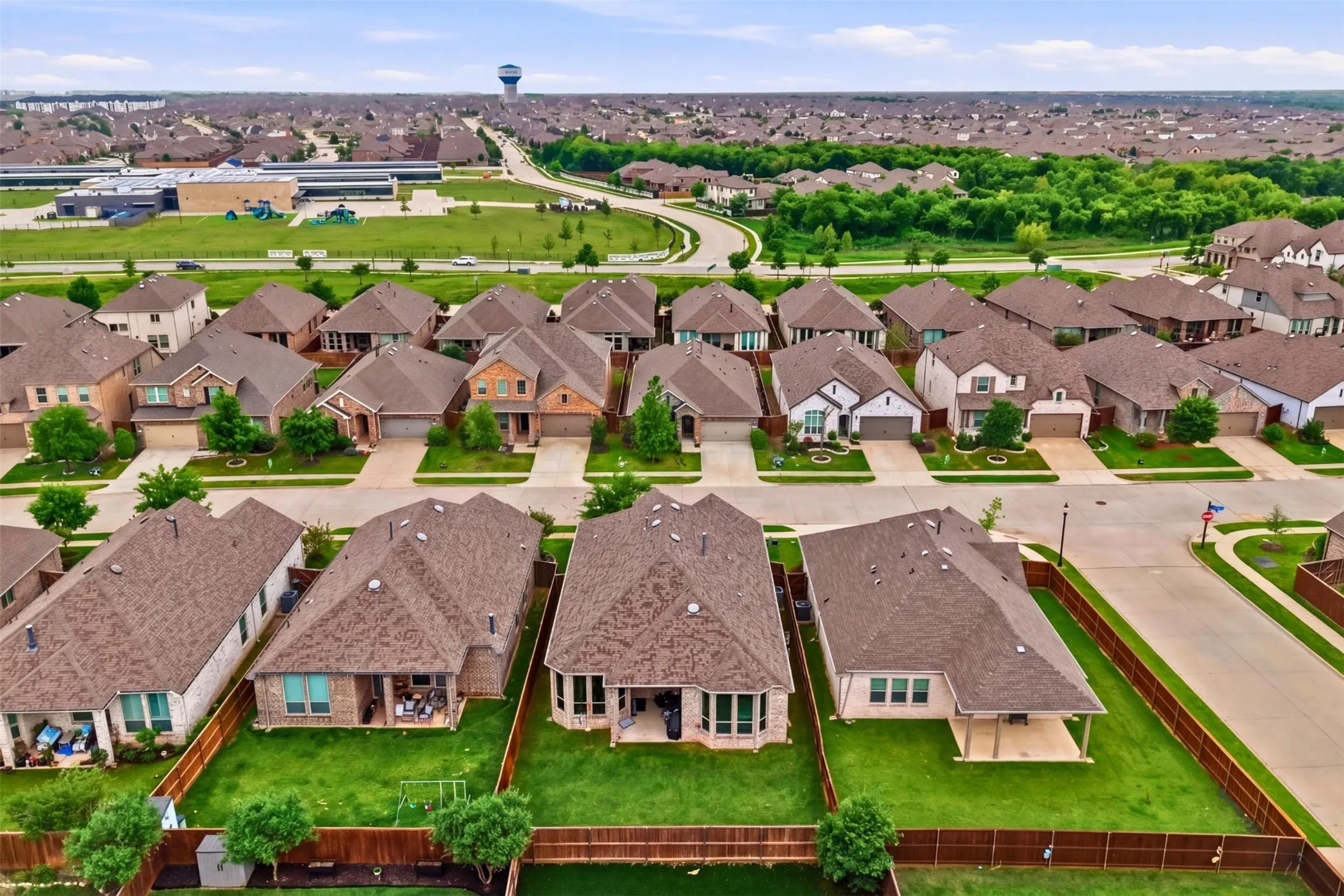 An aerial view of the property, showcasing its well-maintained lawn and private fenced yard