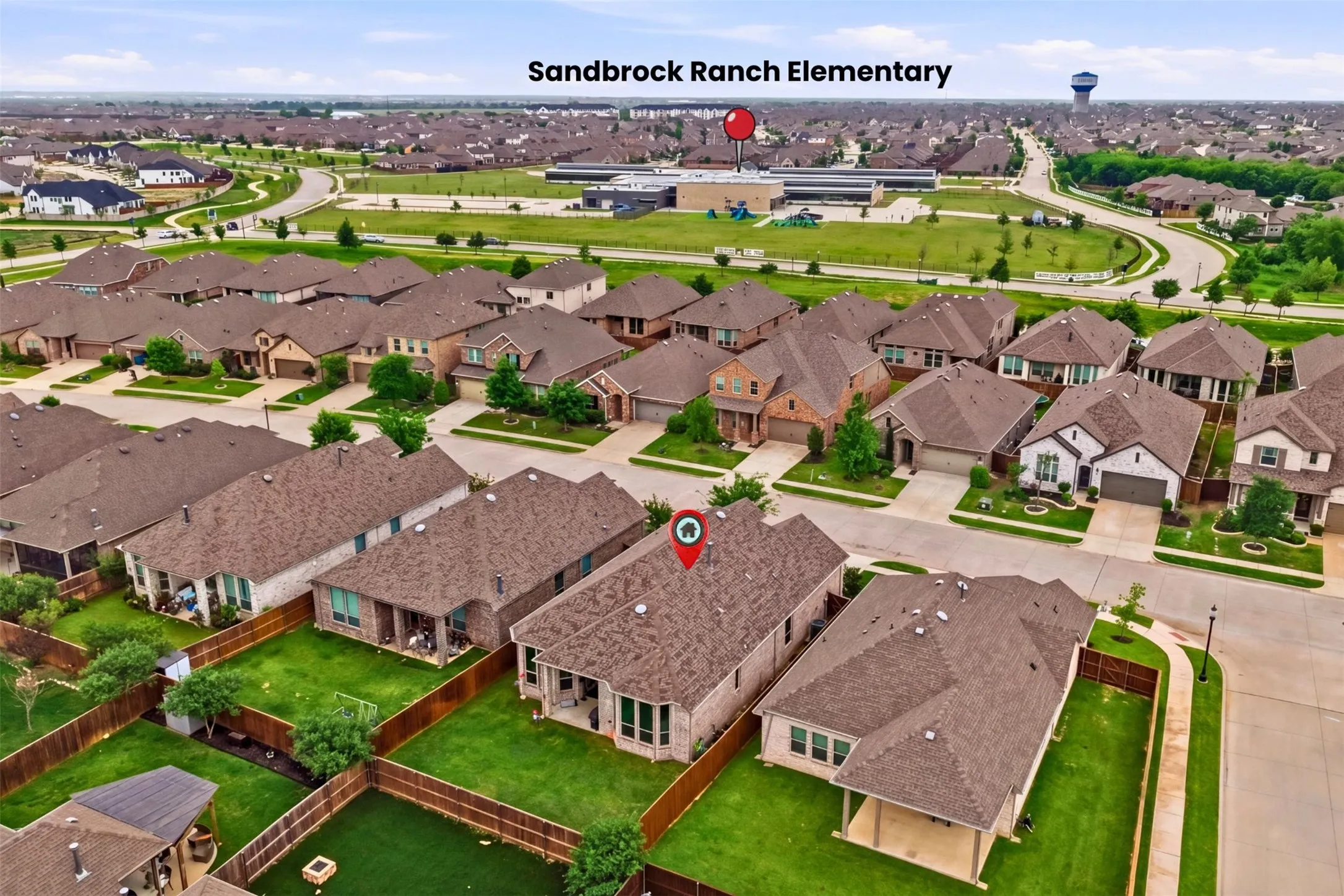 Aerial view of the property and surrounding neighborhood, featuring residential homes with brown shingle roofs, and green lawns