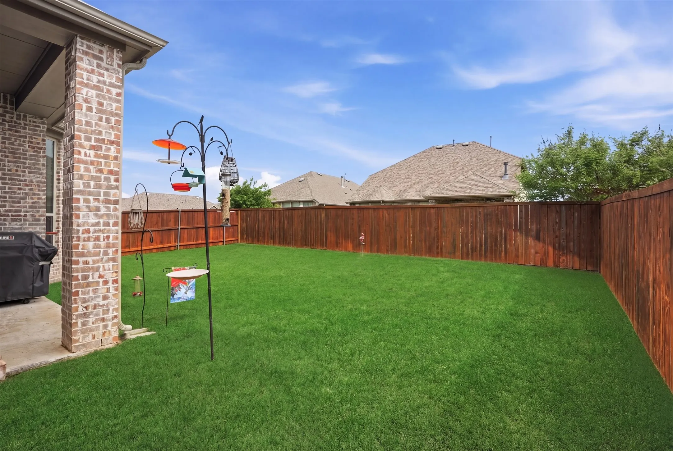 The property features a spacious backyard with a well-maintained lawn and a privacy fence