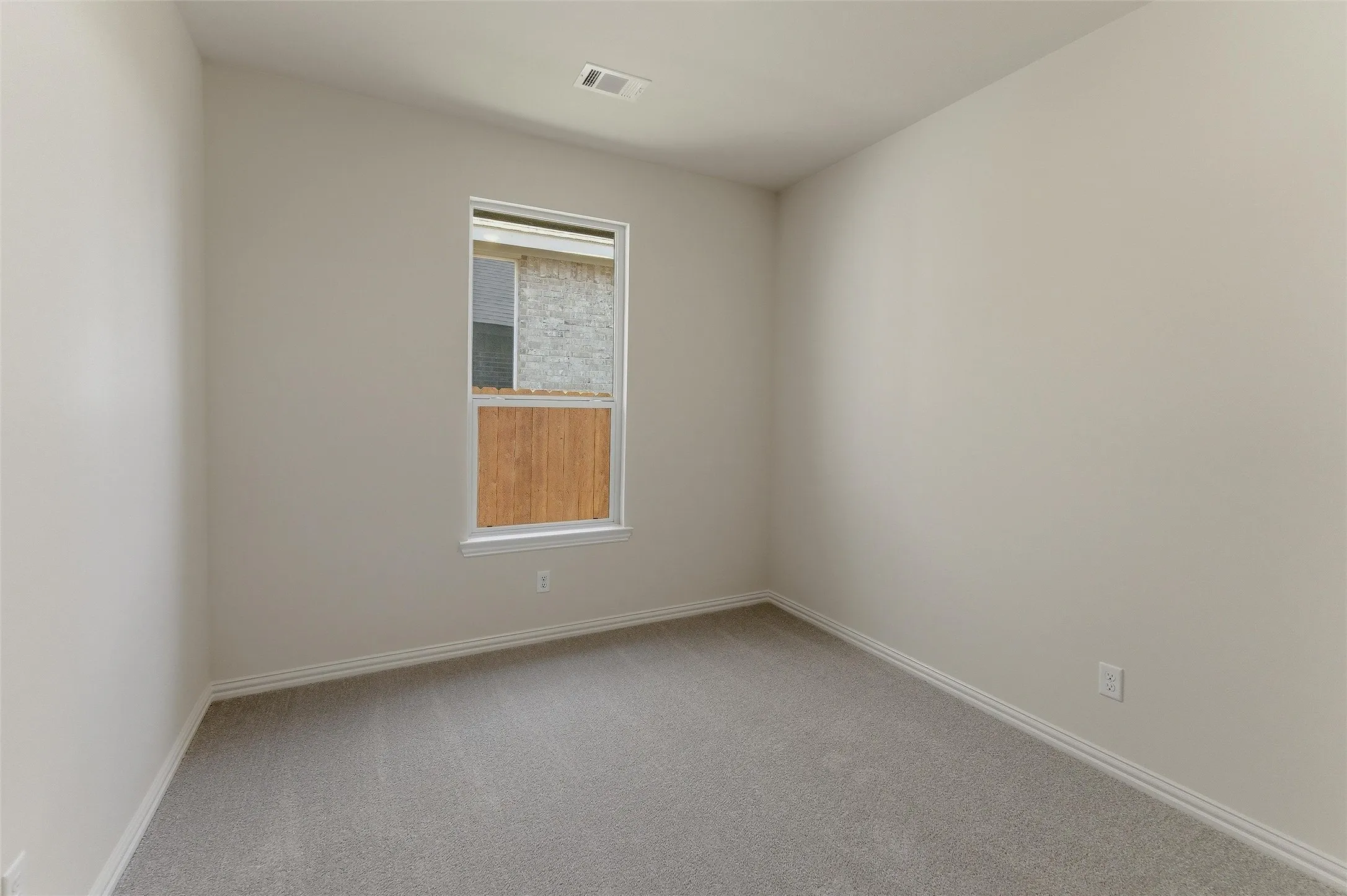 Neutral-toned room with light gray carpeting and white baseboards