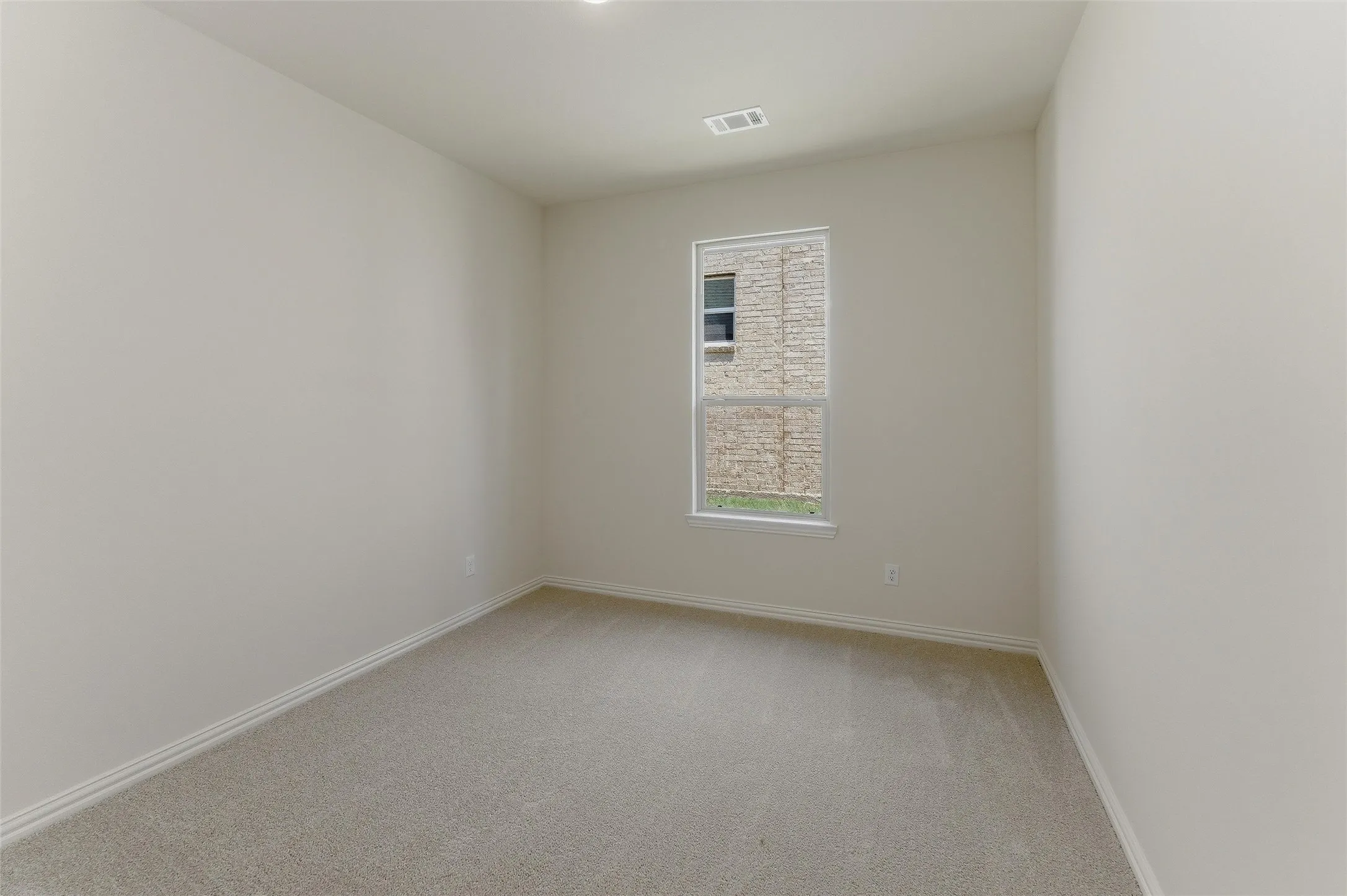 Room featuring light neutral wall tones, clean baseboards, and soft-toned carpeting