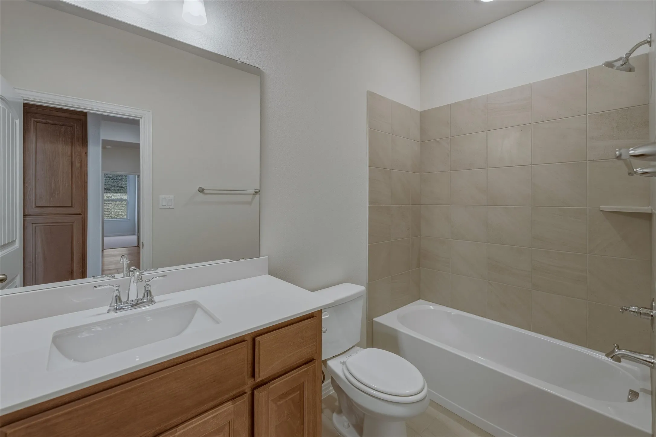 Bathroom featuring a wood-finish vanity with a white countertop, an integrated sink, and a chrome faucet