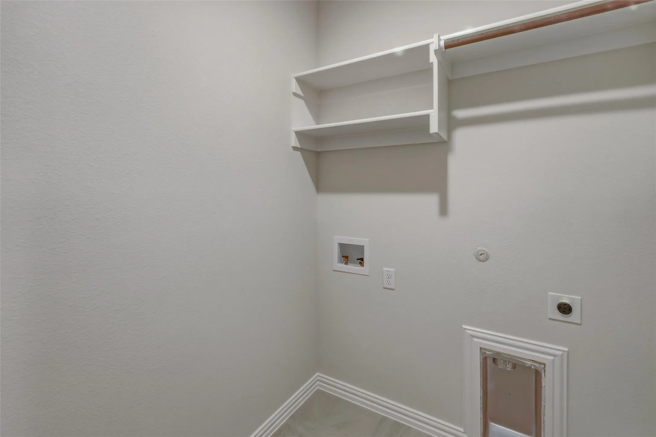 Dedicated utility space featuring built-in shelving, a clothes hanging rod, and essential appliance hookups