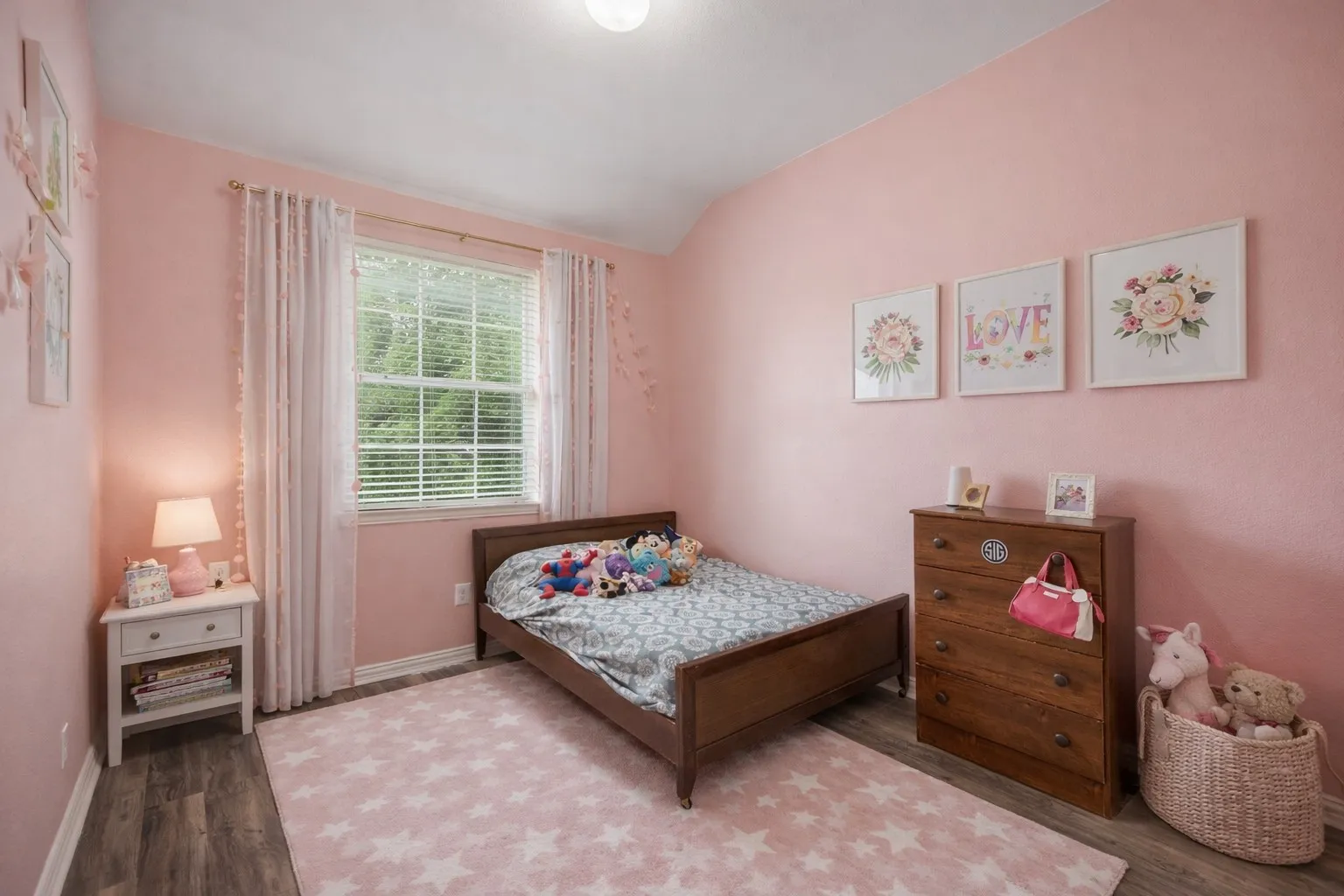 This room features hardwood style flooring, a window with blinds, and a light pink color scheme