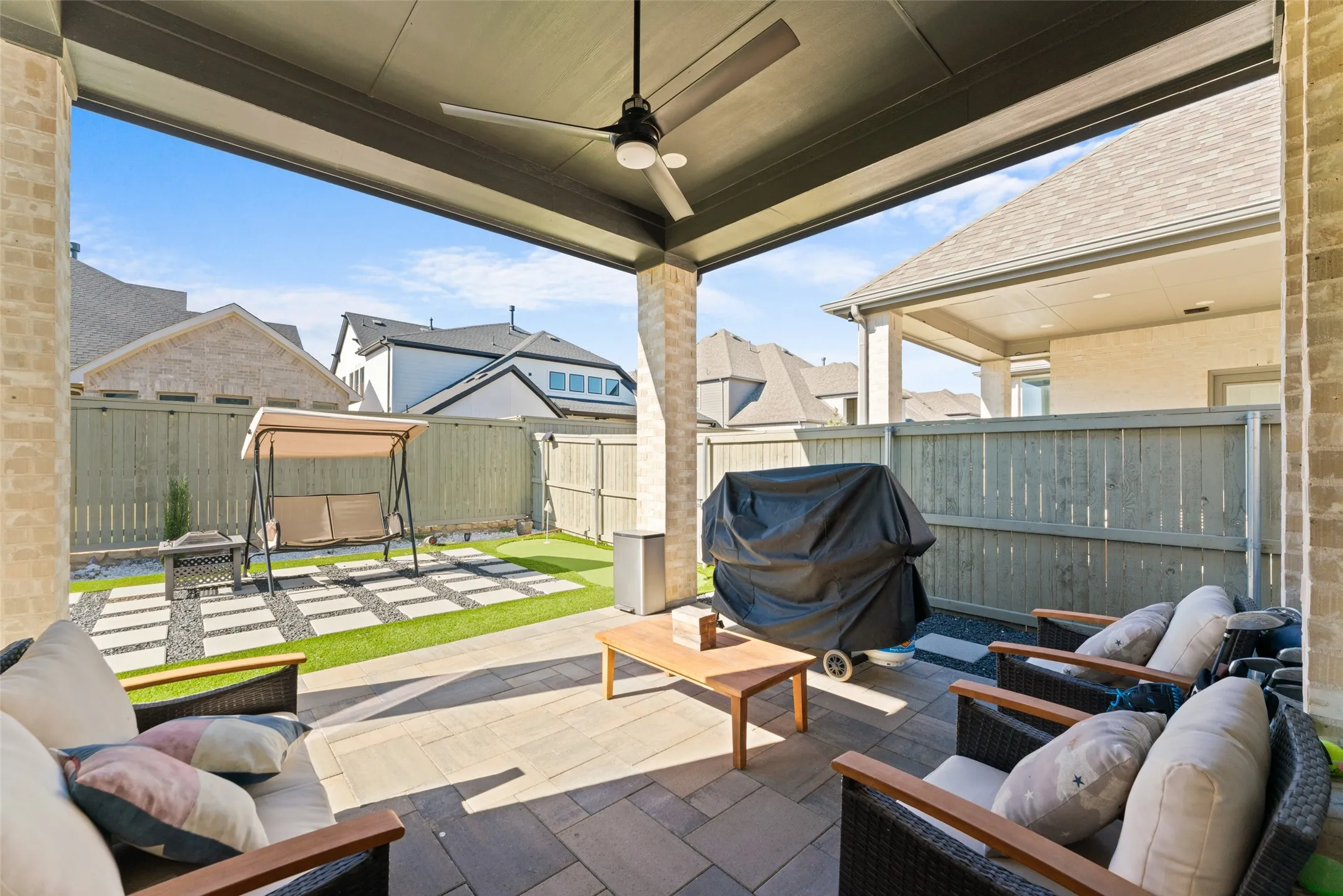 The covered patio features a ceiling fan, providing a comfortable outdoor living space