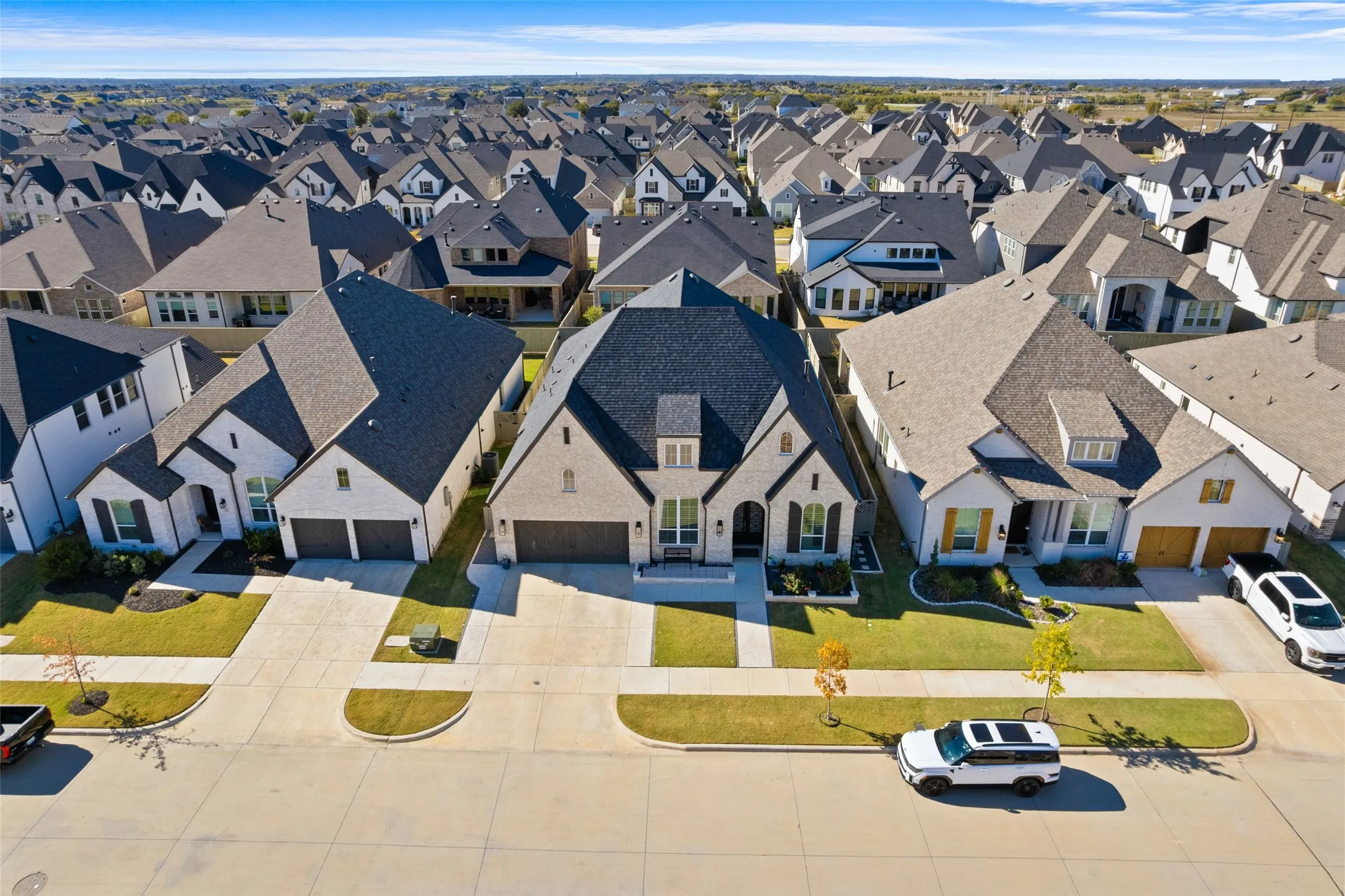 This property features a well-maintained lawn and a paved driveway leading to a two-car garage