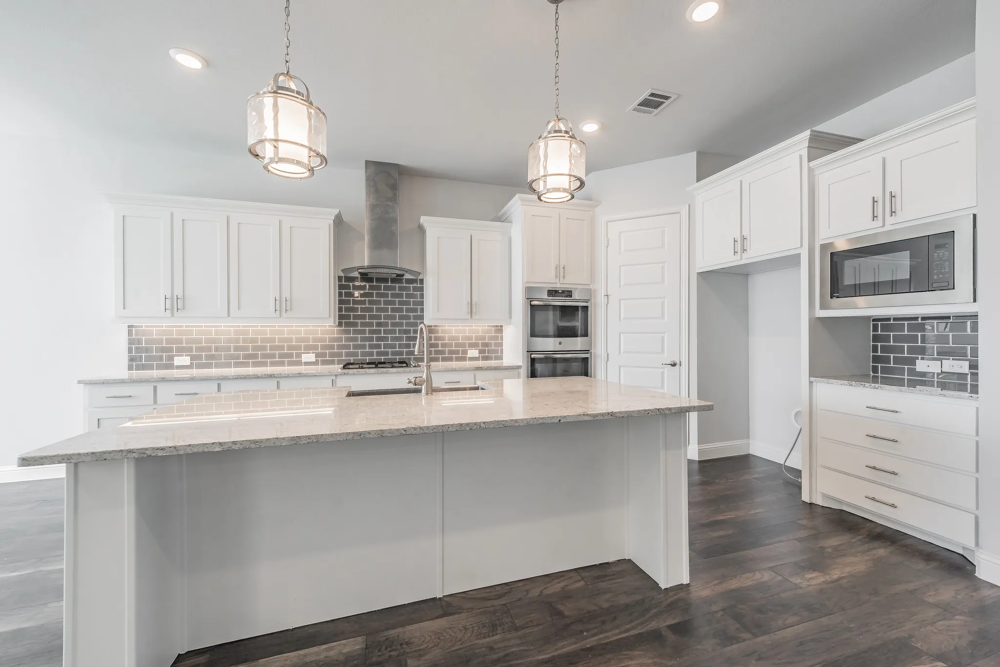 Kitchen featuring backsplash, light stone counters, white cabinetry, appliances with stainless steel finishes, and recessed lighting