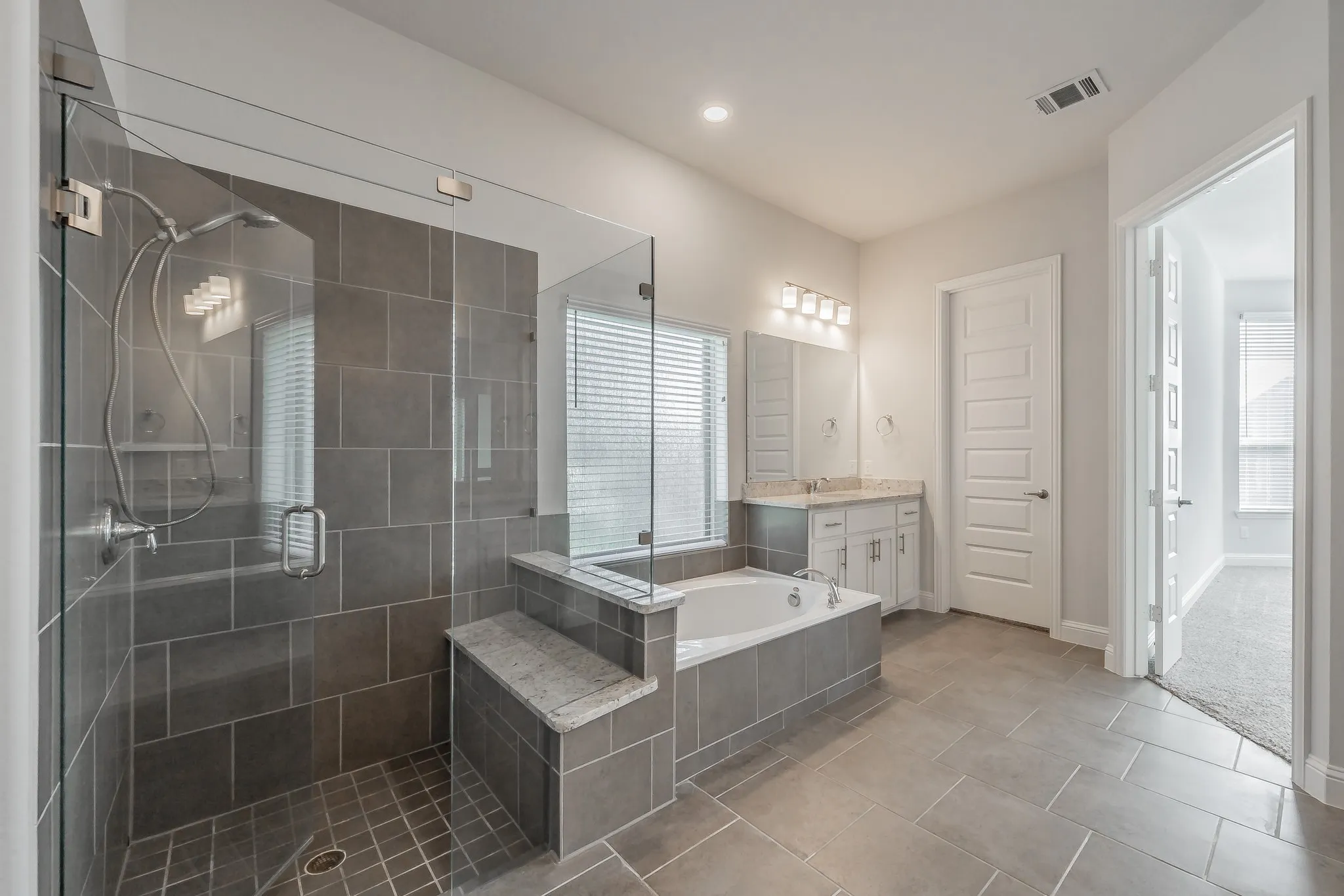 Full bath featuring a bath, vanity, a stall shower, light tile patterned flooring, and recessed lighting