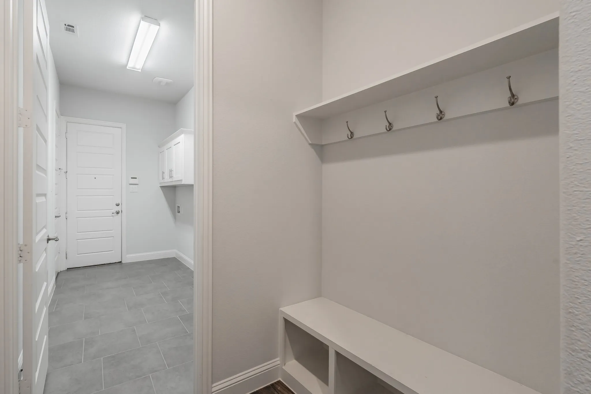Mudroom featuring baseboards and dark tile patterned flooring