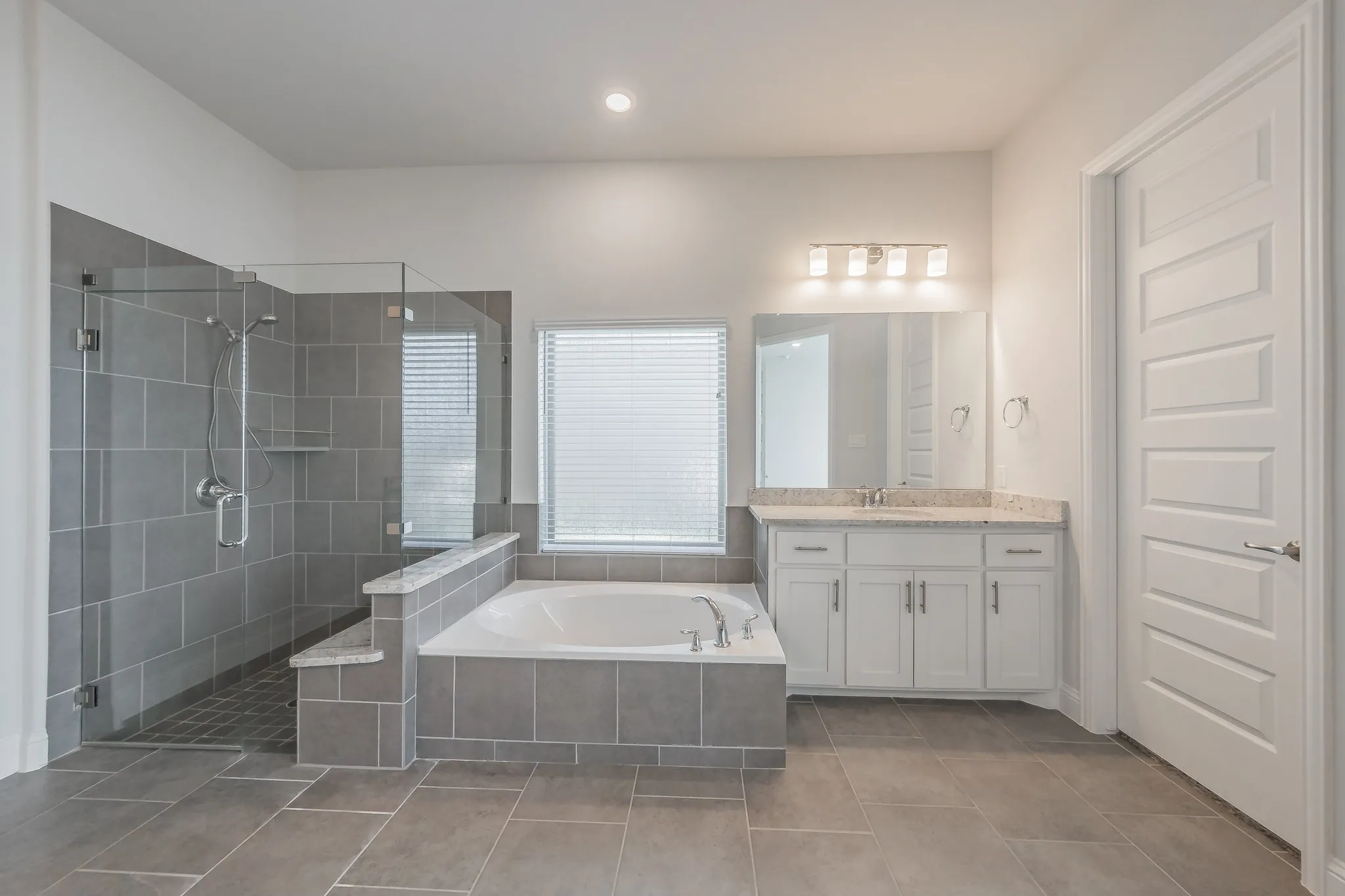 Full bath featuring a garden tub, vanity, a stall shower, light tile patterned floors, and recessed lighting