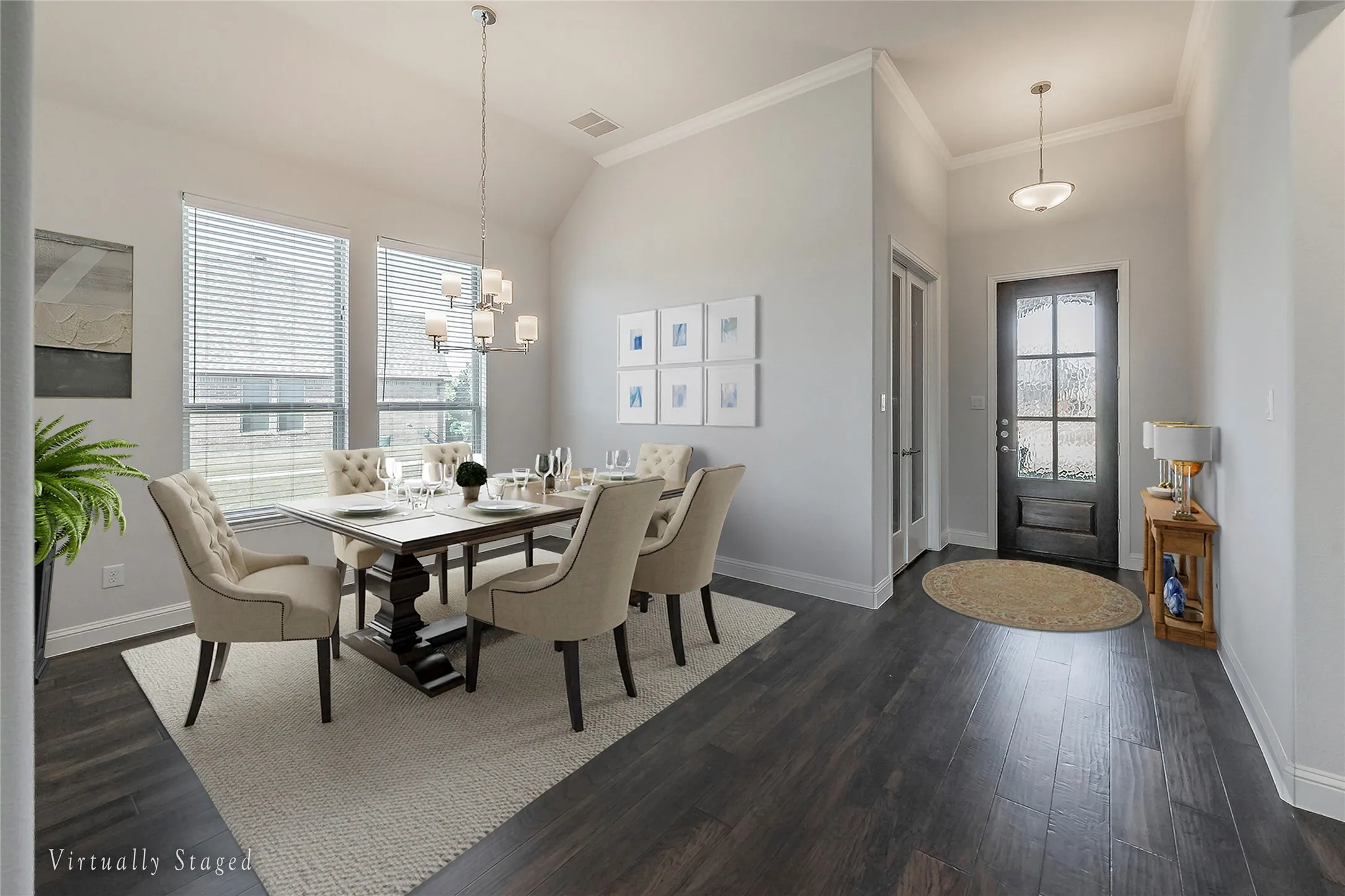 Virtually Staged - Dining area with a chandelier, dark wood-style floors, ornamental molding, and vaulted ceiling