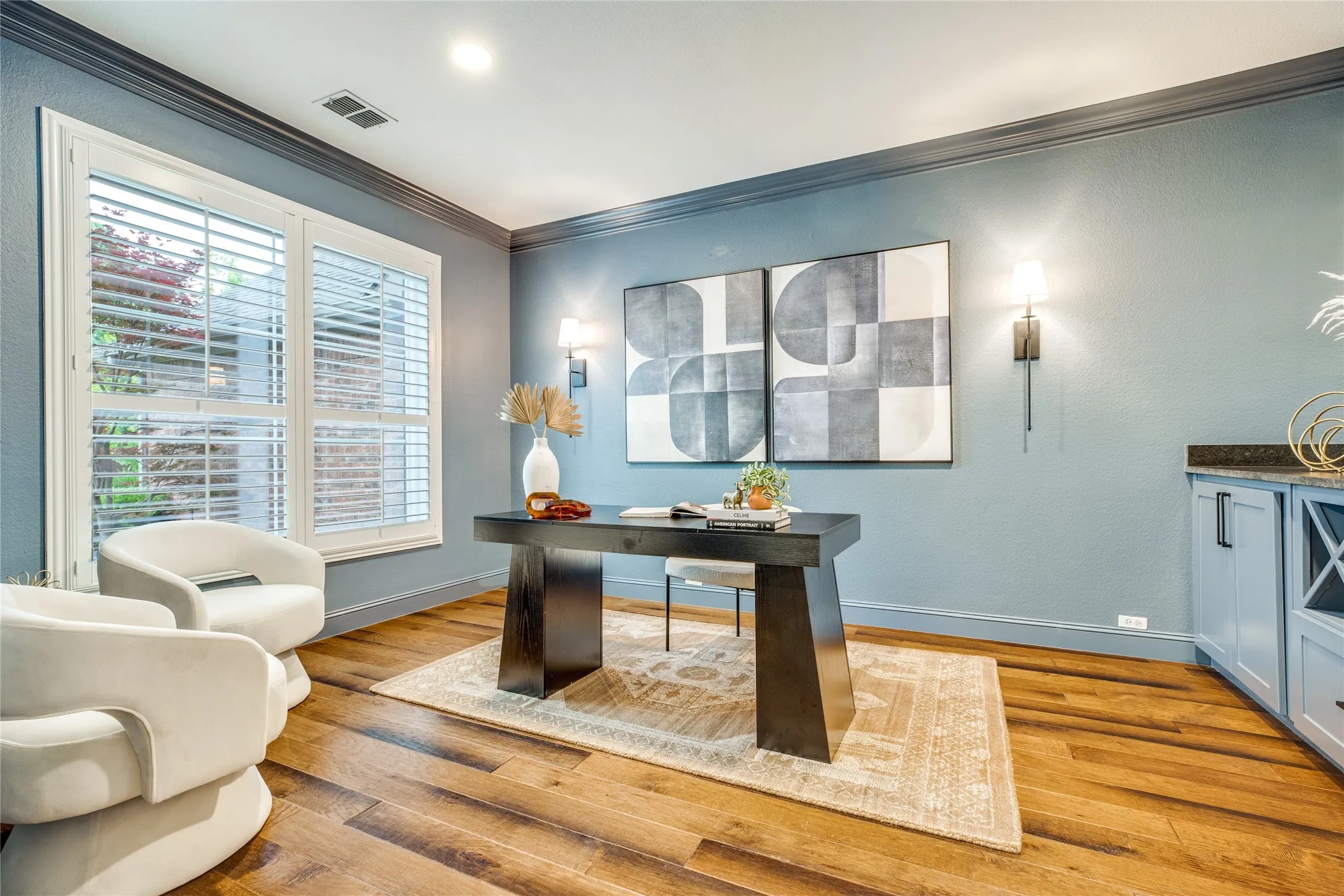 This room features hardwood flooring, blue walls, and a built-in cabinet with a dark countertop