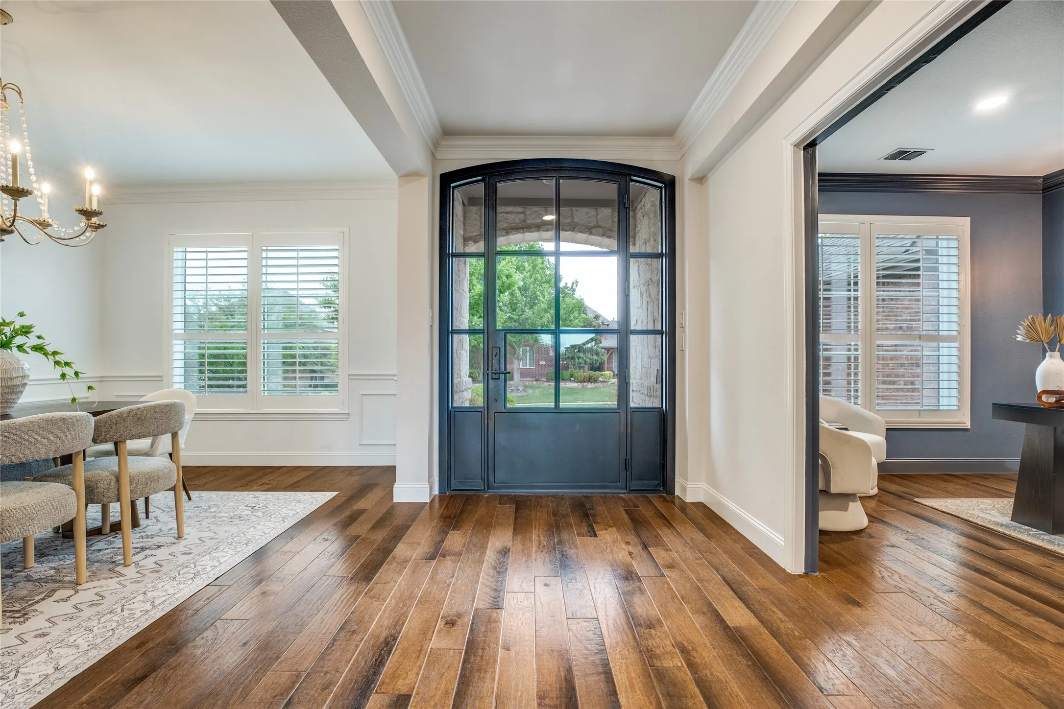 Entryway featuring rich hardwood flooring, a glass panel door with an arched top, and white trim molding
