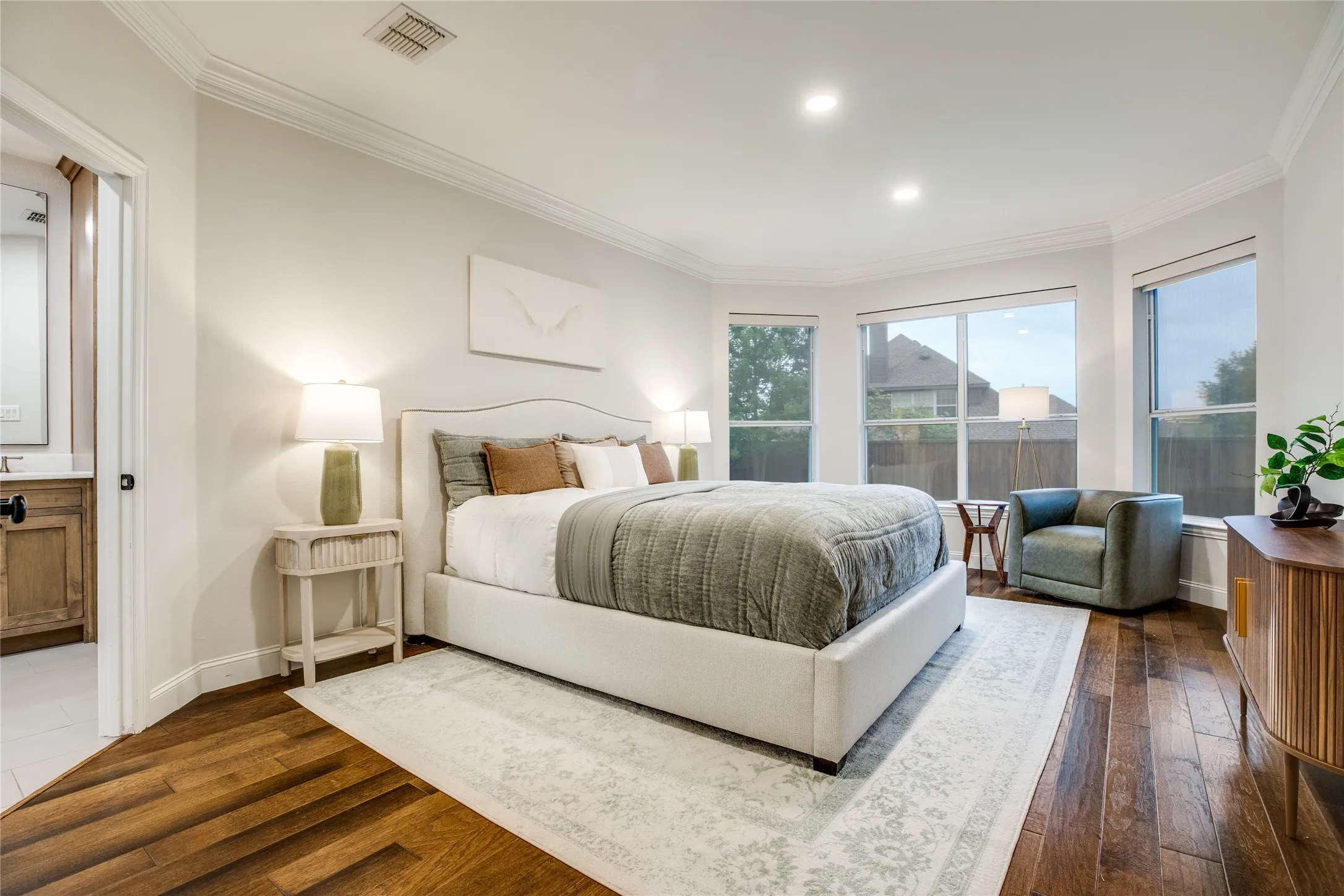 This room features rich hardwood flooring, recessed lighting, and a bay window providing natural light