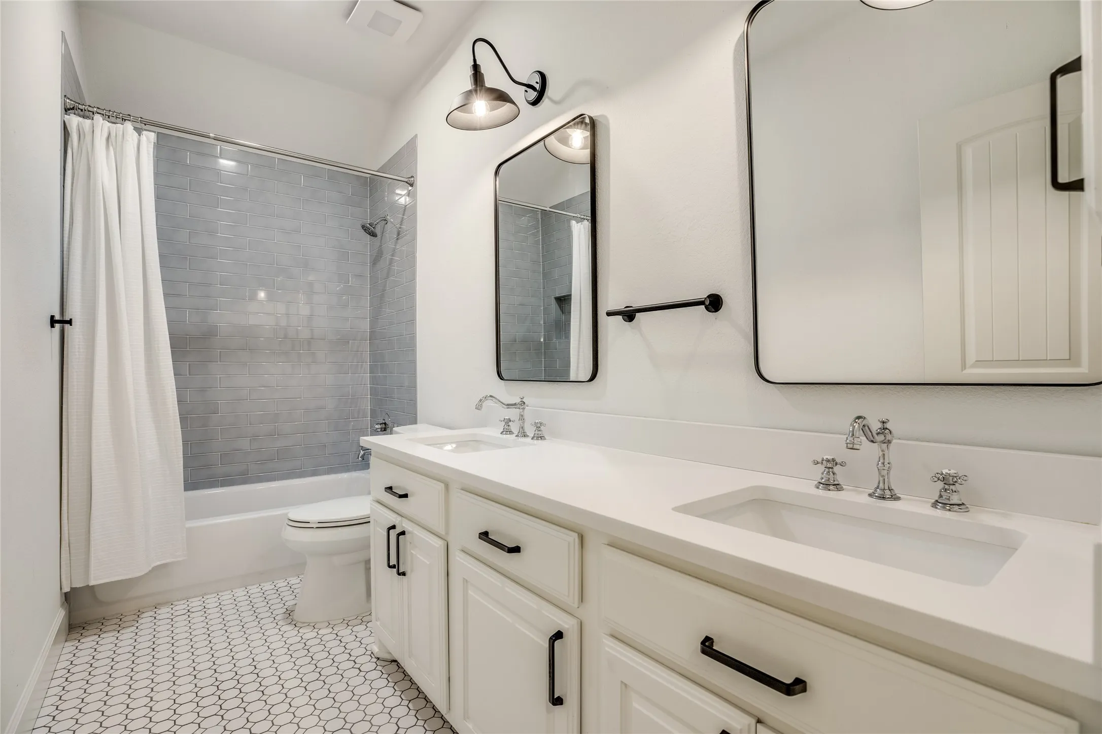 Bathroom featuring a double vanity with white cabinetry, white countertops, and chrome faucets