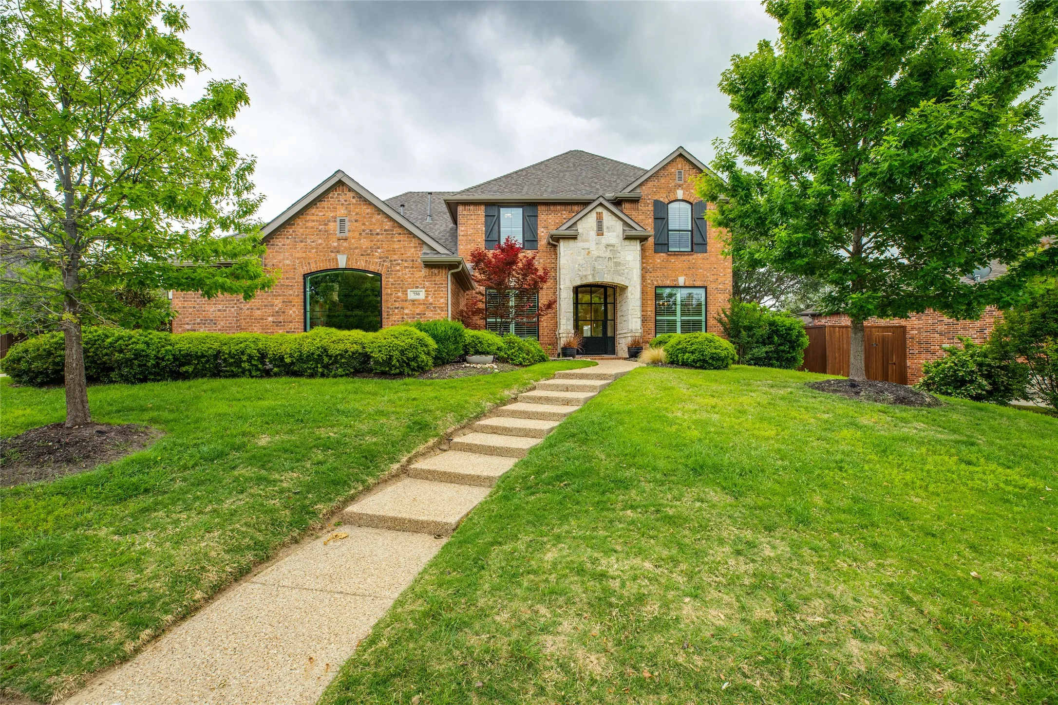The property features a brick exterior with stone accents and a well-maintained lawn