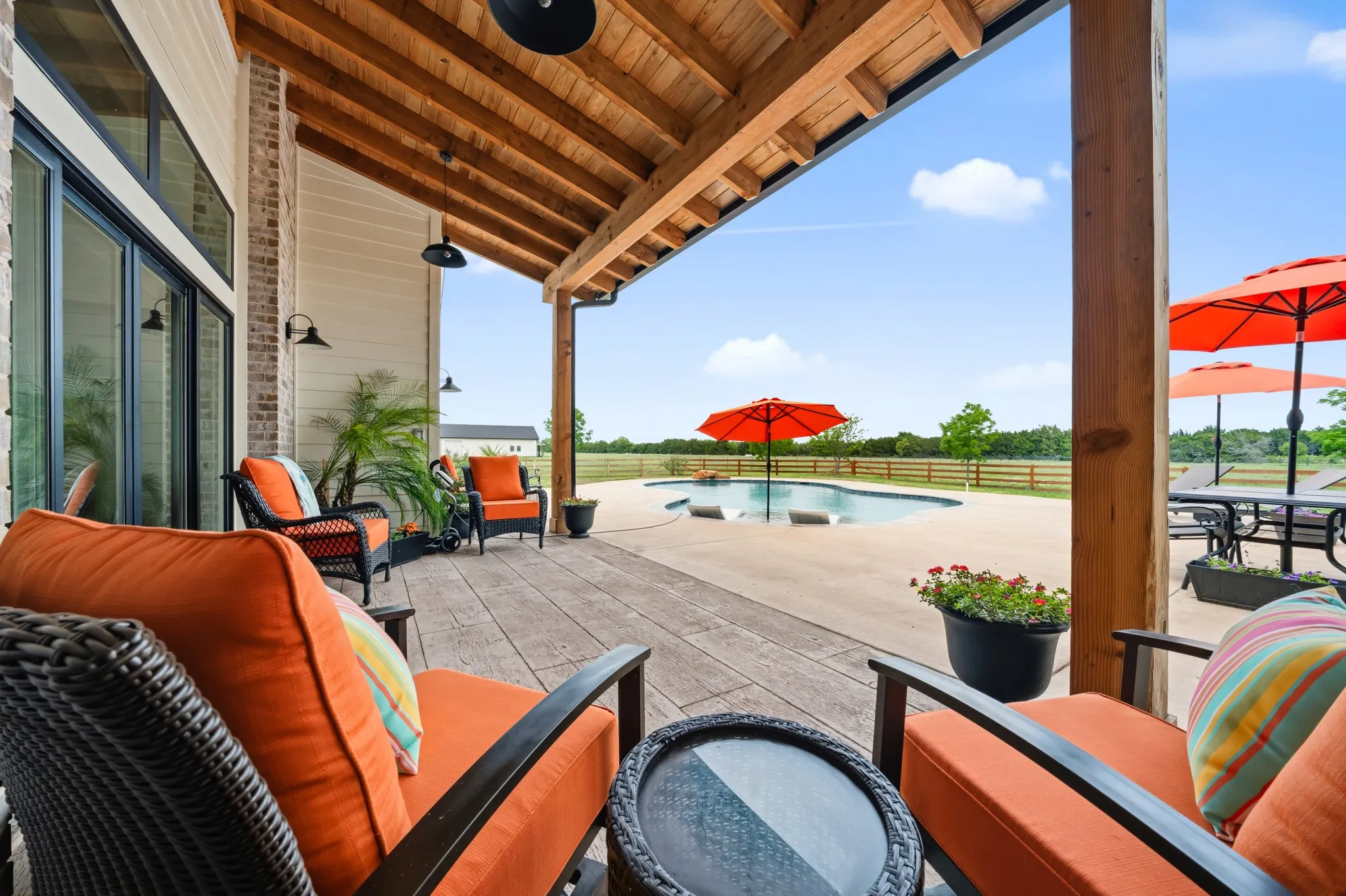The property features a covered patio with a wood ceiling, wood beam columns, and a large sliding glass door