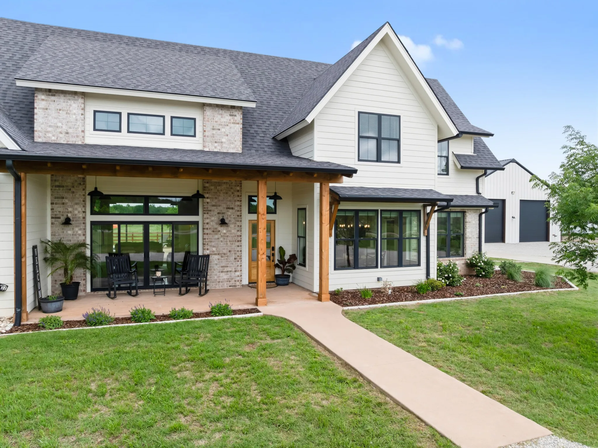 The property presents an appealing exterior with white siding, black-framed windows, and a dark shingle roof