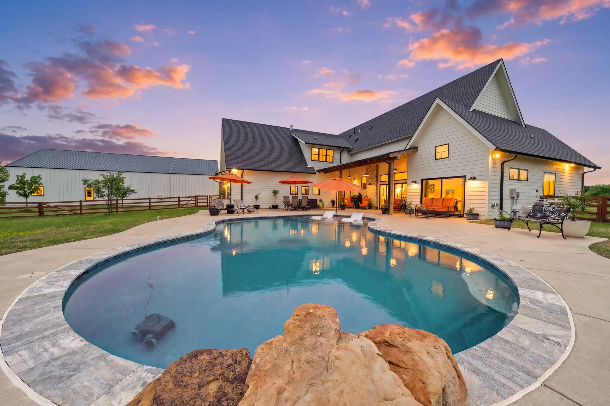 The property features a large outdoor swimming pool with a concrete surround, and a spacious patio area