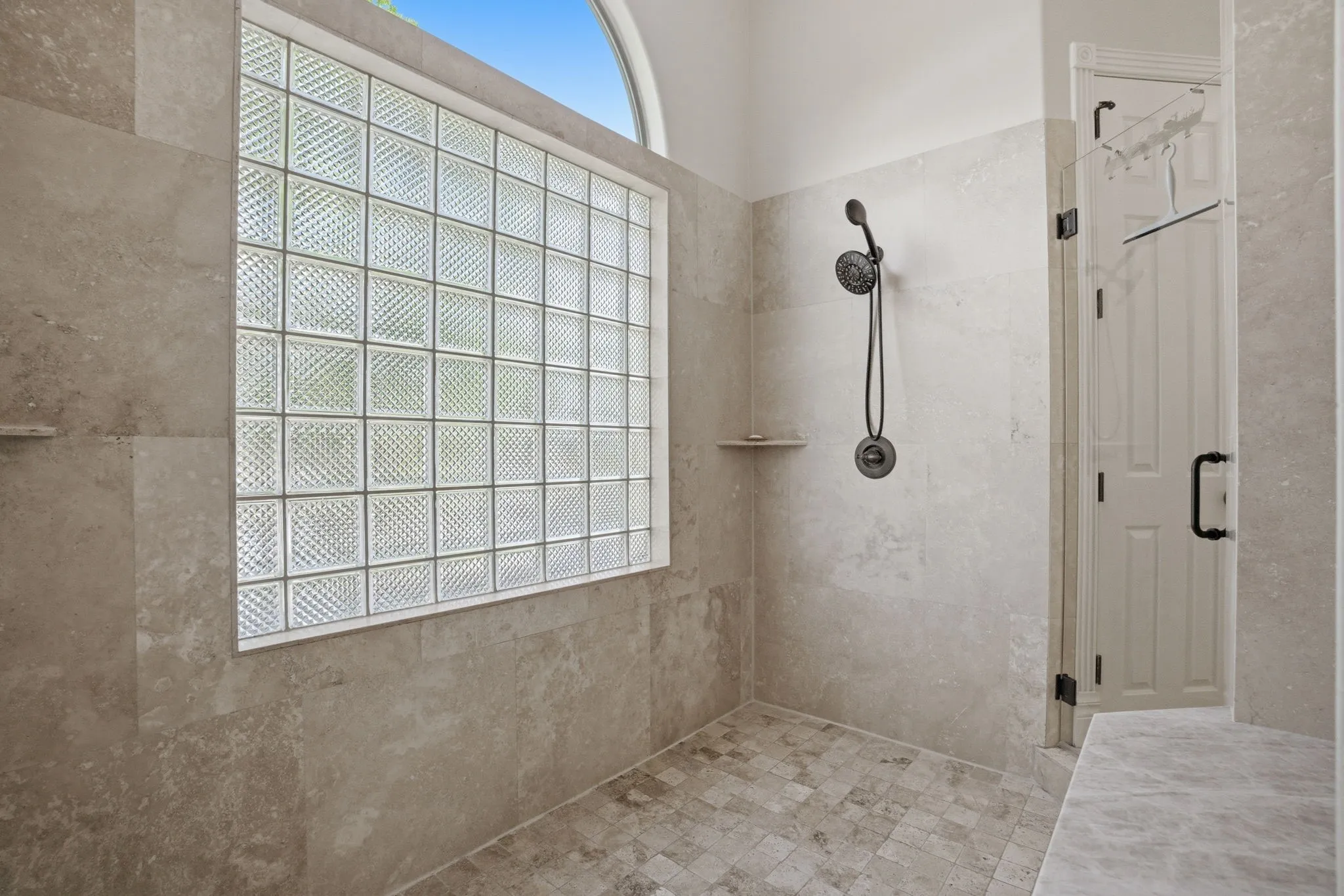 Enhancing the spa experience, the massive walk-in shower has frameless doors on each entry side.