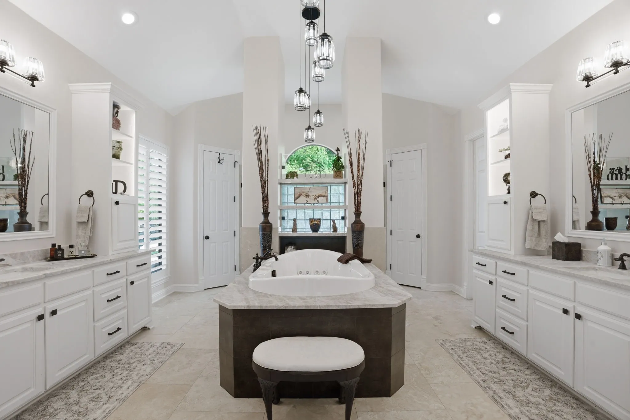 The remodeled primary bath is defined by clean lines & thoughtfully chosen finishes. Fusion Quartzite countertops adorn the vast amount of cabinets.  Noteworthy tiered pendant lighting over the deep Jetta Jacuzzi luxury spa tub with hydro & action jets. A true spa experience! His & hers walk-in closets too.
