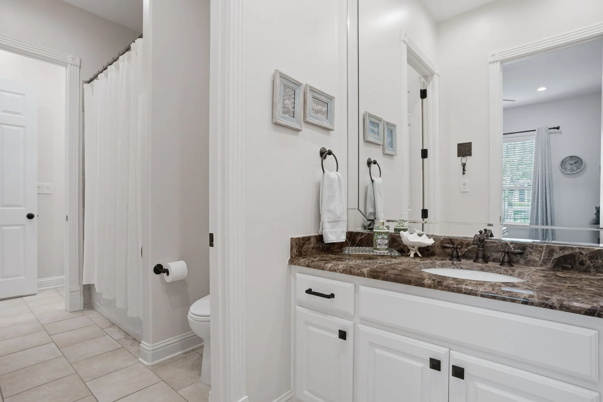 Shared full bath between bedrooms 3 & 4, each with a wide granite countertop & ample storage.