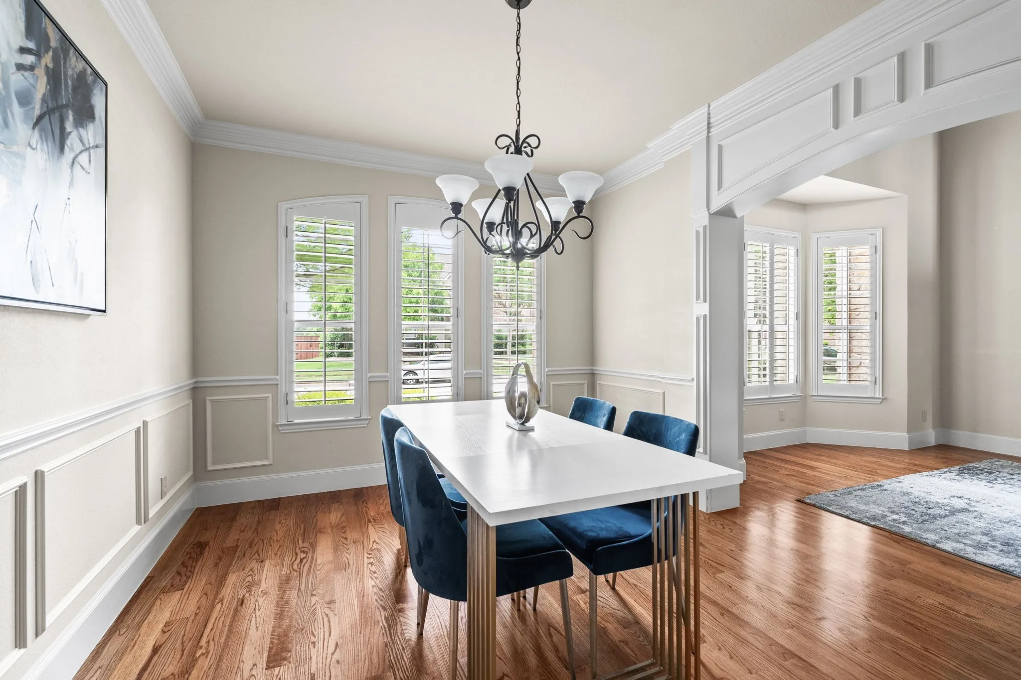 Gorgeous hardwood floors with crown moldings, chair railing and beautiful archway.
