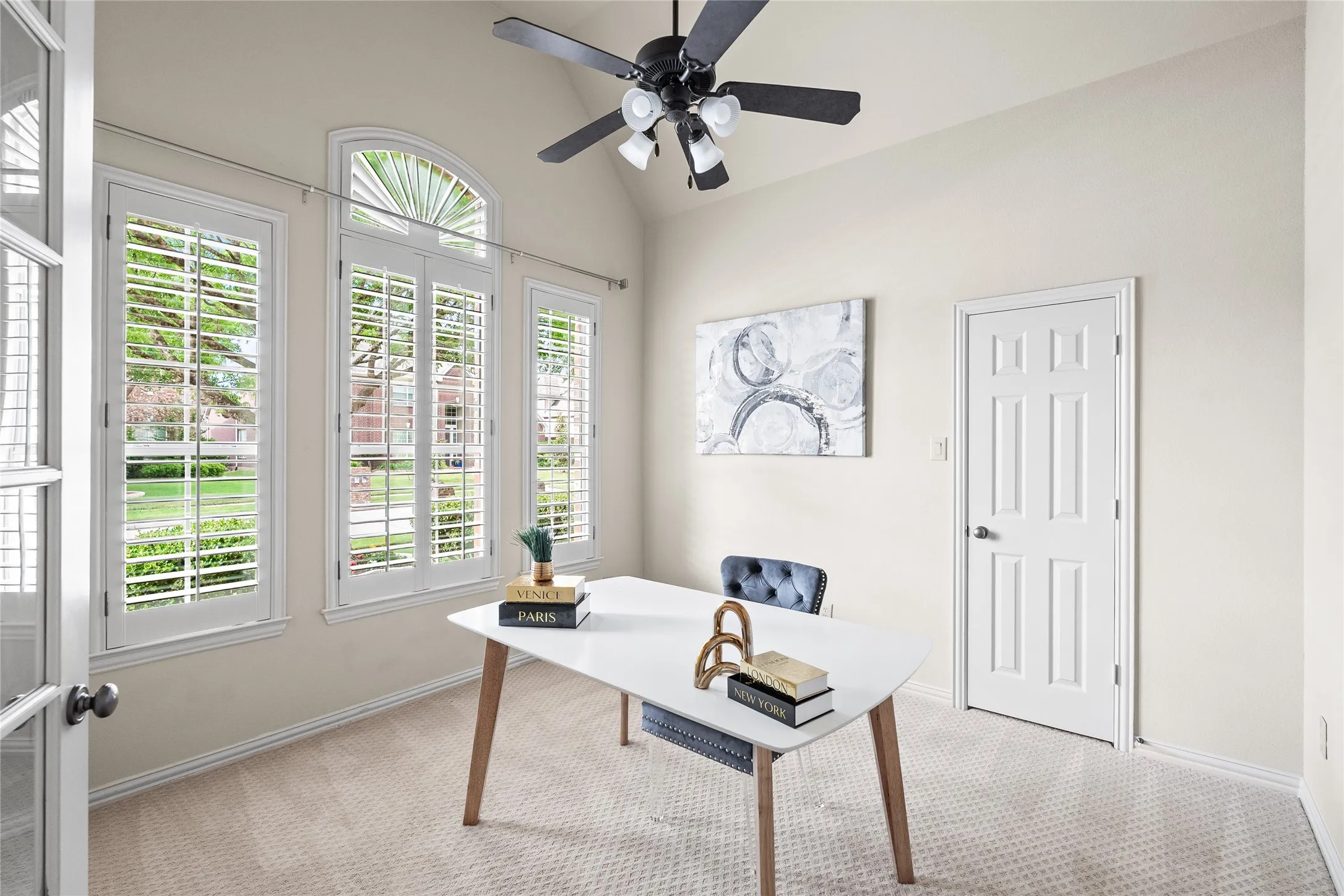 Large office with closet, soaring ceilings and plantation shutters.