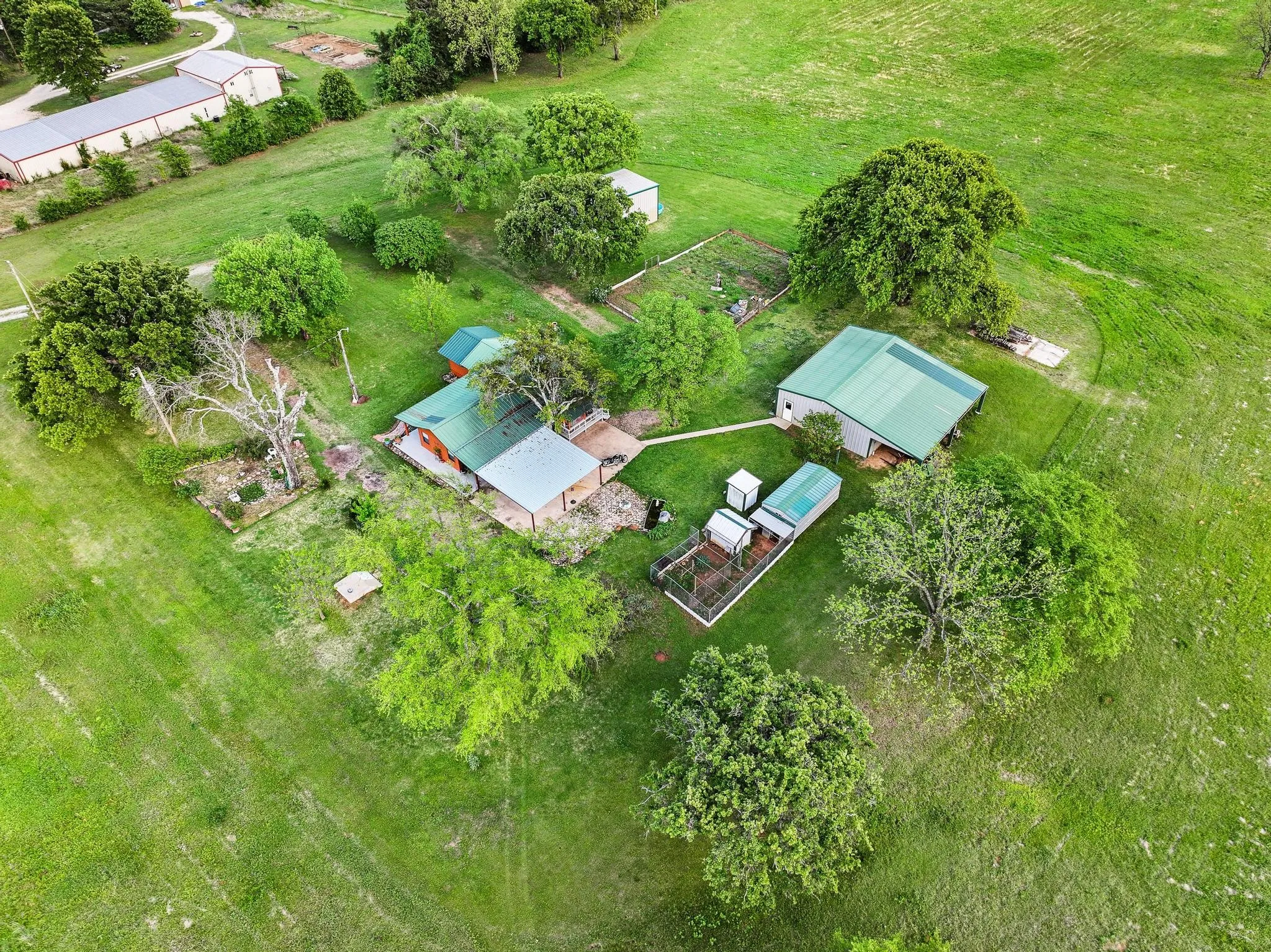 This property features a main residence with a green roof, accompanied by an additional structure with a green metal roof