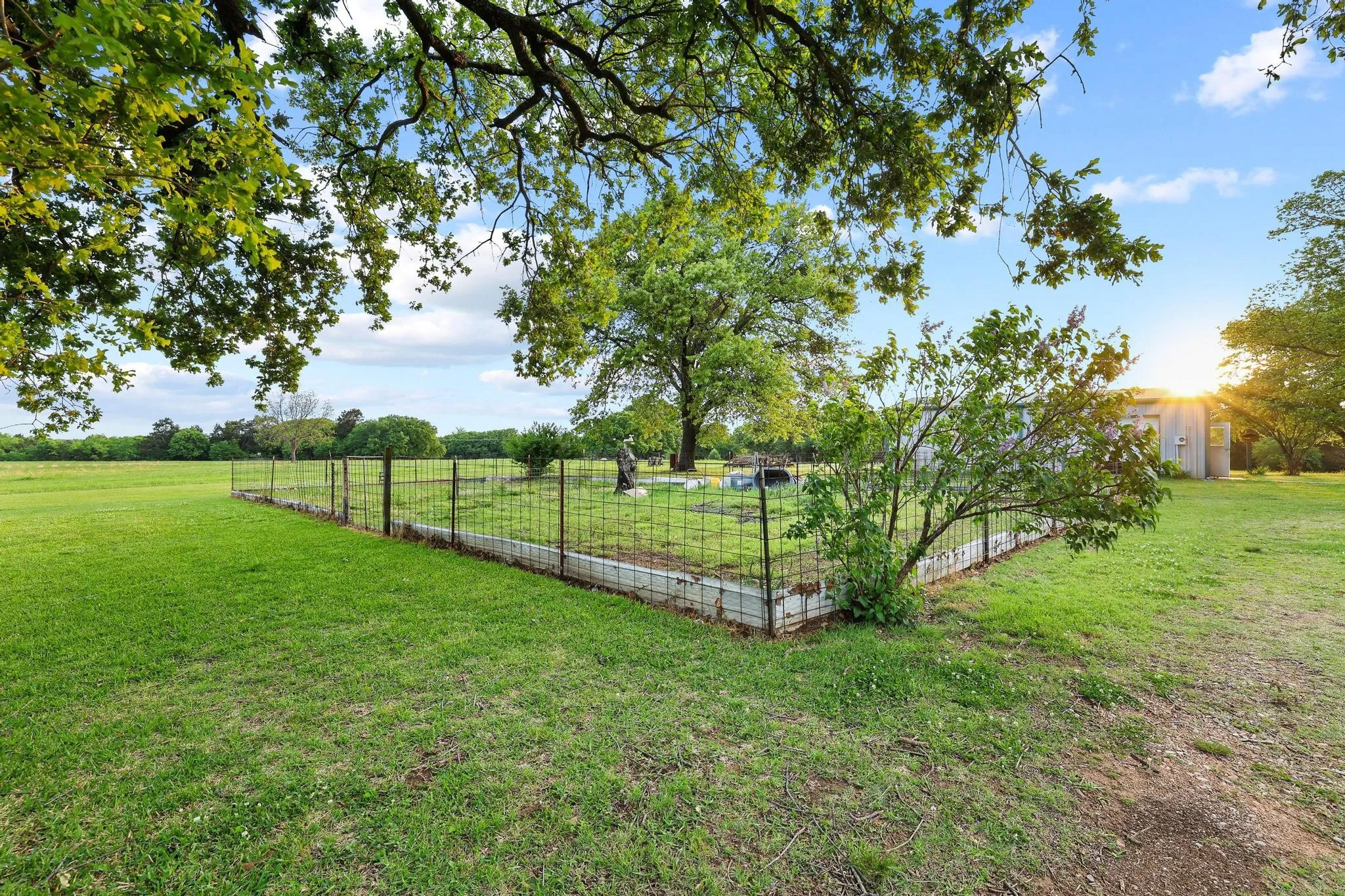 The property features a spacious yard with a well-maintained lawn and mature trees, offering a serene outdoor environment