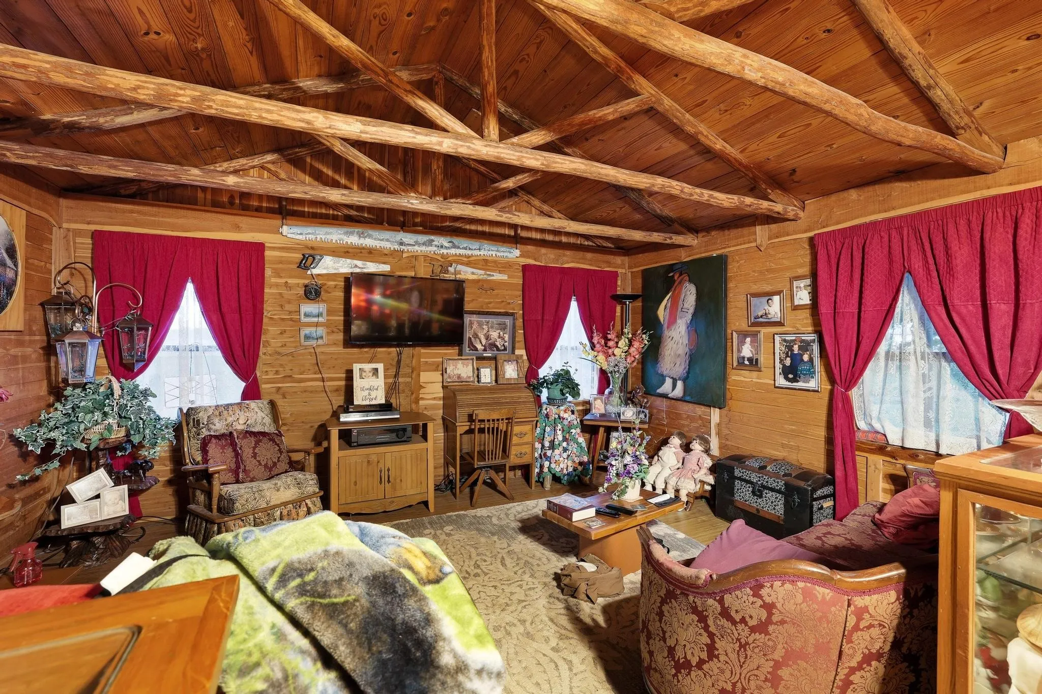 This inviting room features exposed wood beam ceilings and wood paneling throughout, creating a rustic aesthetic